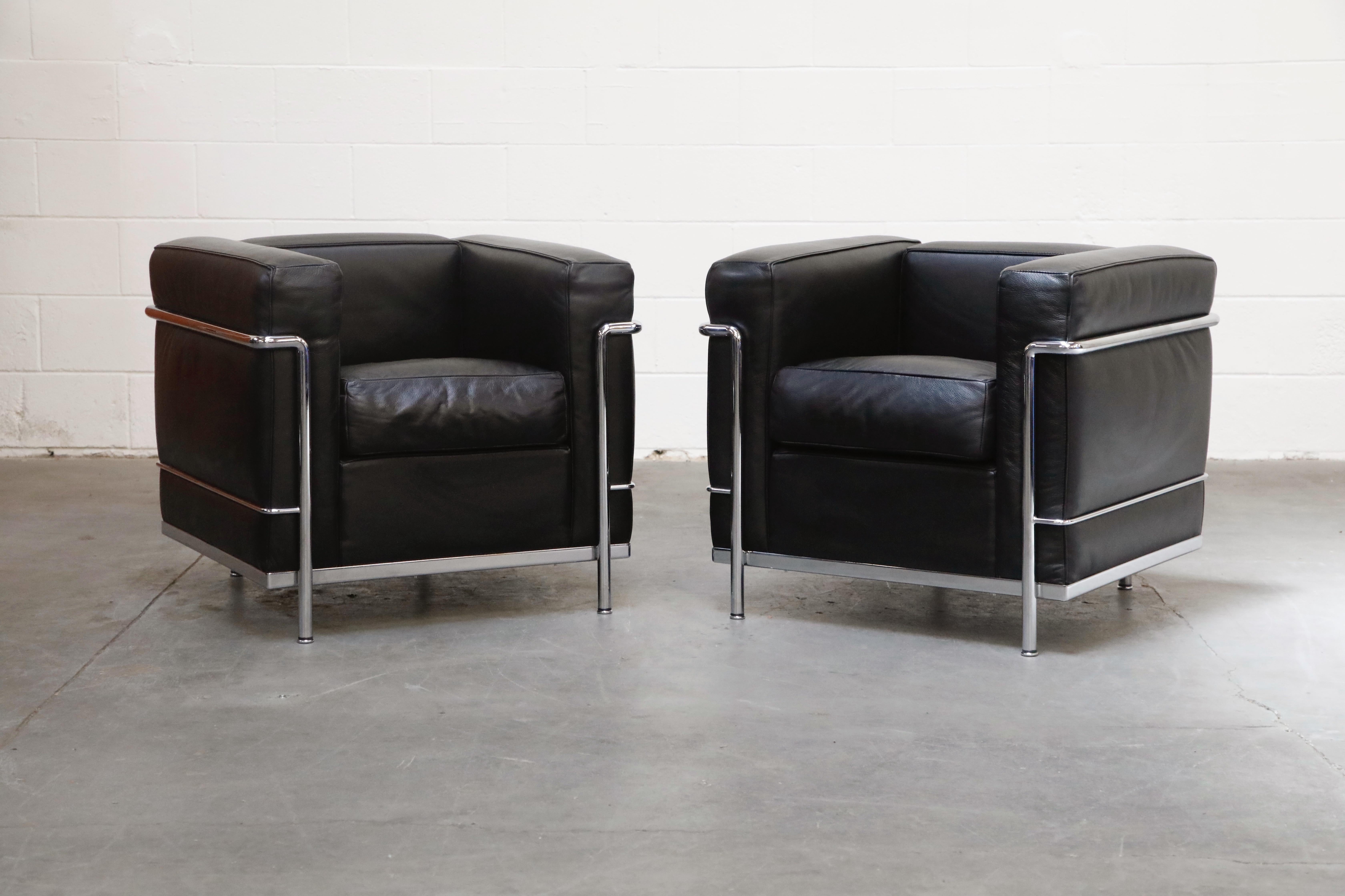 This incredibly comfortable set of Le Corbusier for Cassina (signed) LC2's in gorgeous thick Italian black leather include two club chairs and one three-seat sofa, priced in this listing as a set of three. 

The LC2 was designed in 1928 by Le