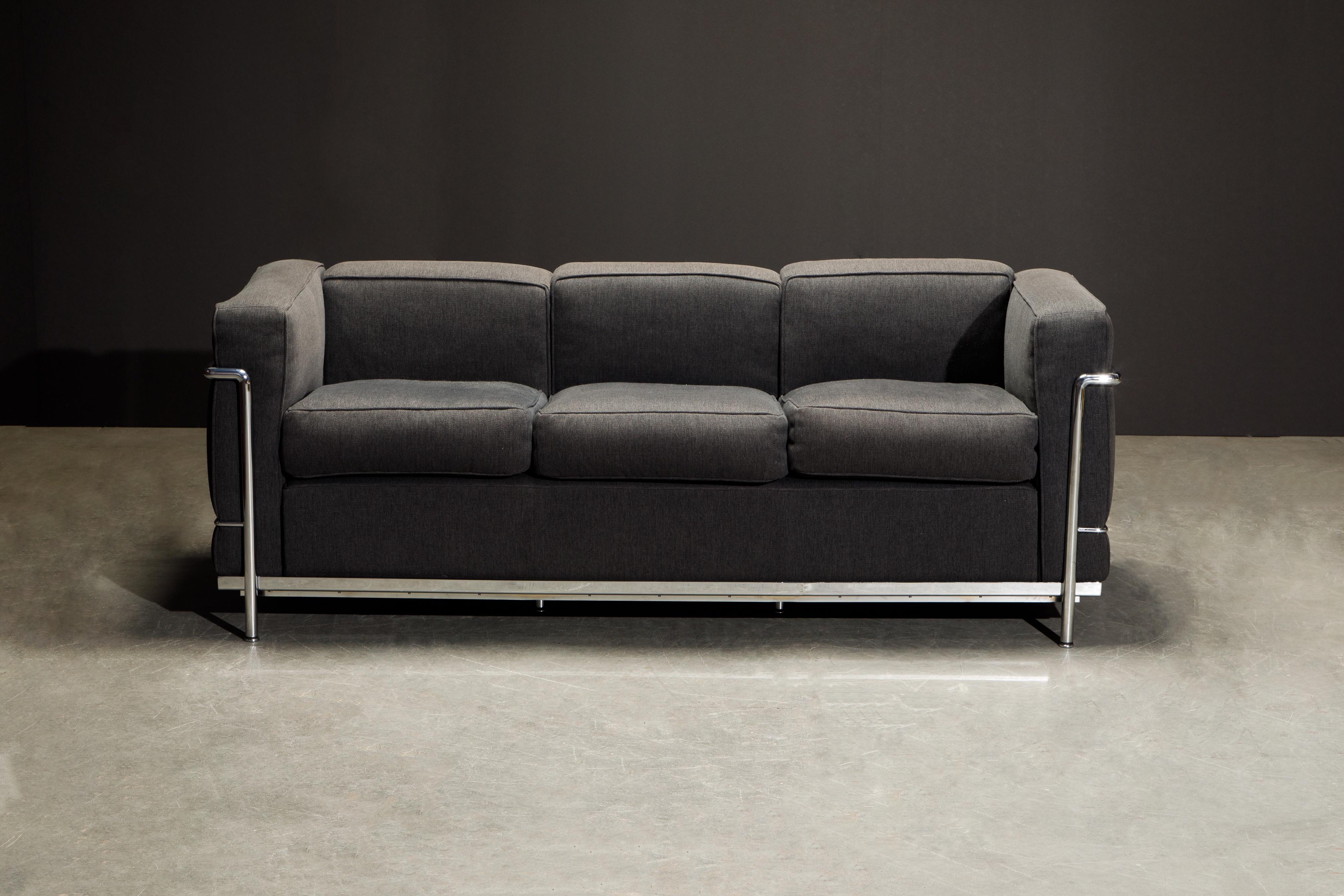 This incredibly comfortable Le Corbusier for Cassina (authentic signed) LC2 three-seat sofa with charcoal grey fabric cushions and tubular chrome frame. 

The LC2 was designed in 1928 by Le Corbusier; his cousin and colleague Pierre Jeanneret; and