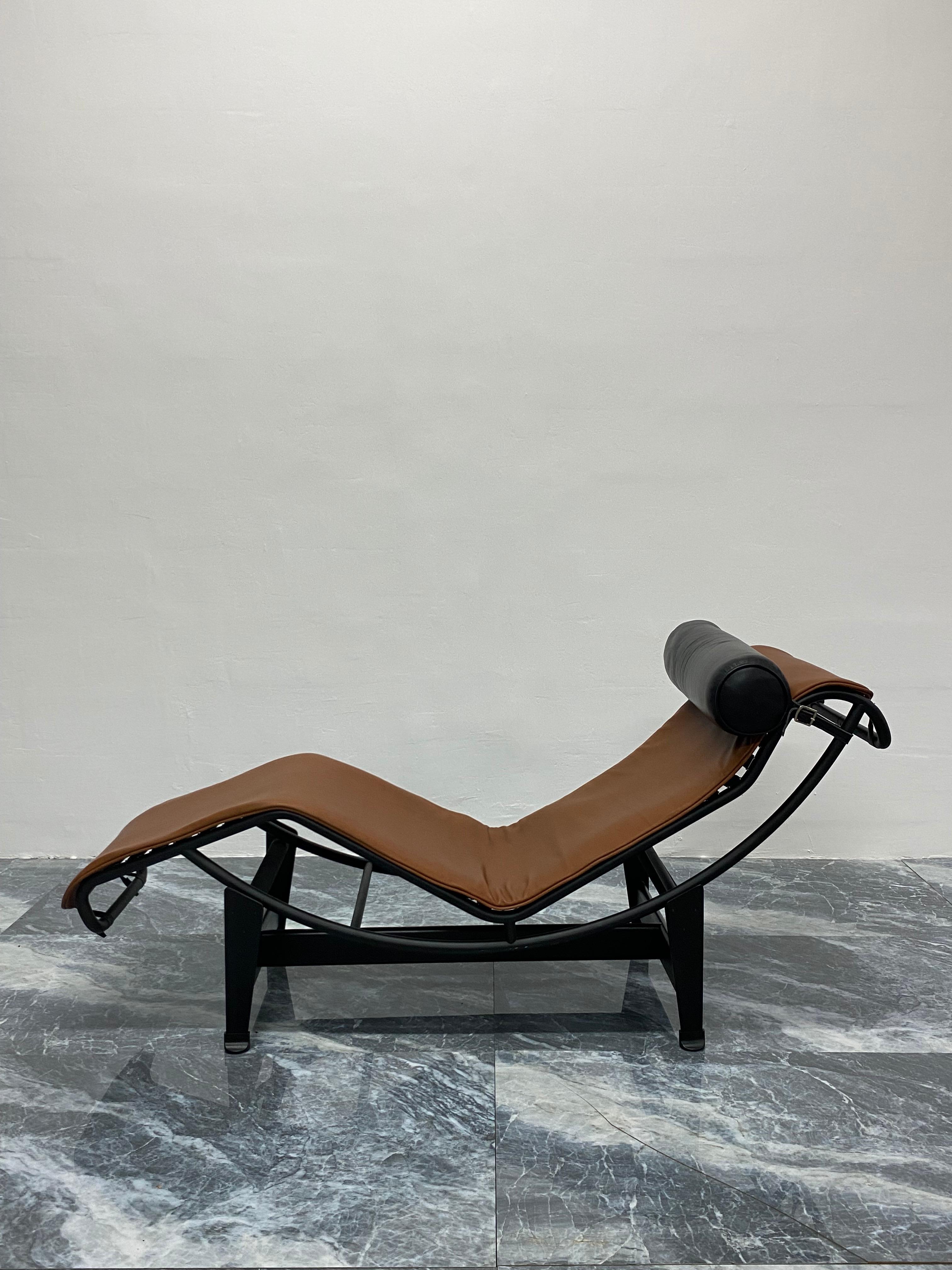 Brown leather LC4 Noire chaise lounge with black leather bolster pillow on black tubular chrome and black steel base by Le Corbusier, Pierre Jeanneret and Charlotte Perriand for Cassina. Signed and inscribed on the base and the chaise. 

In 1922, Le