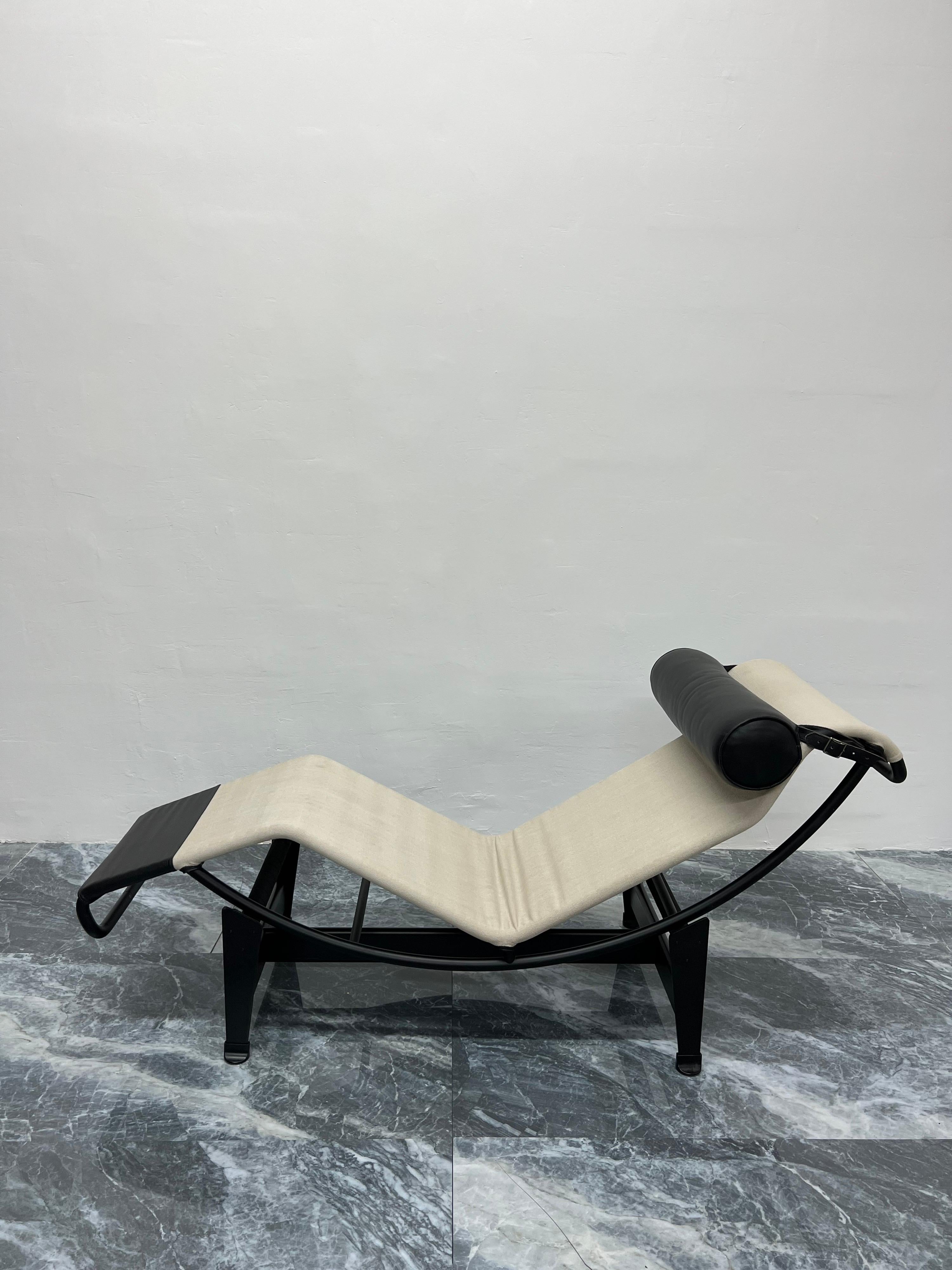 Black leather and beige canvas LC4 Noire chaise lounge with black leather bolster pillow on black tubular chrome and black steel base by Le Corbusier, Pierre Jeanneret and Charlotte Perriand for Cassina. Signed and inscribed on the base and the