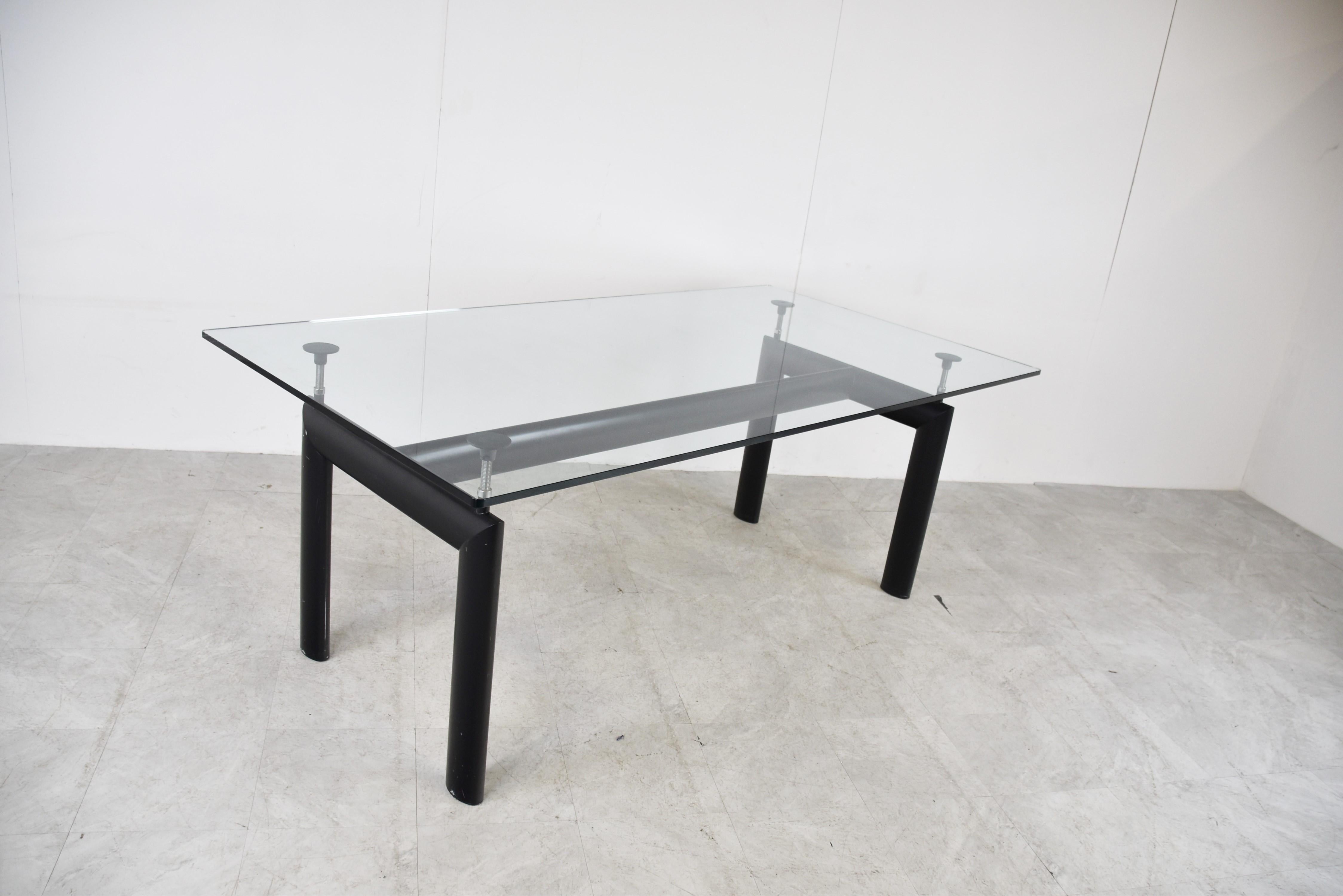Table de salle à manger conçue par Le Corbusier, Pierre Jeanneret, Charlotte Perriand à l'origine en 1928 pour le Salon d'Automne à Paris et relancée en 1974 par Cassina.

Elle se compose d'une base en aluminium noir avec 4 supports réglables qui