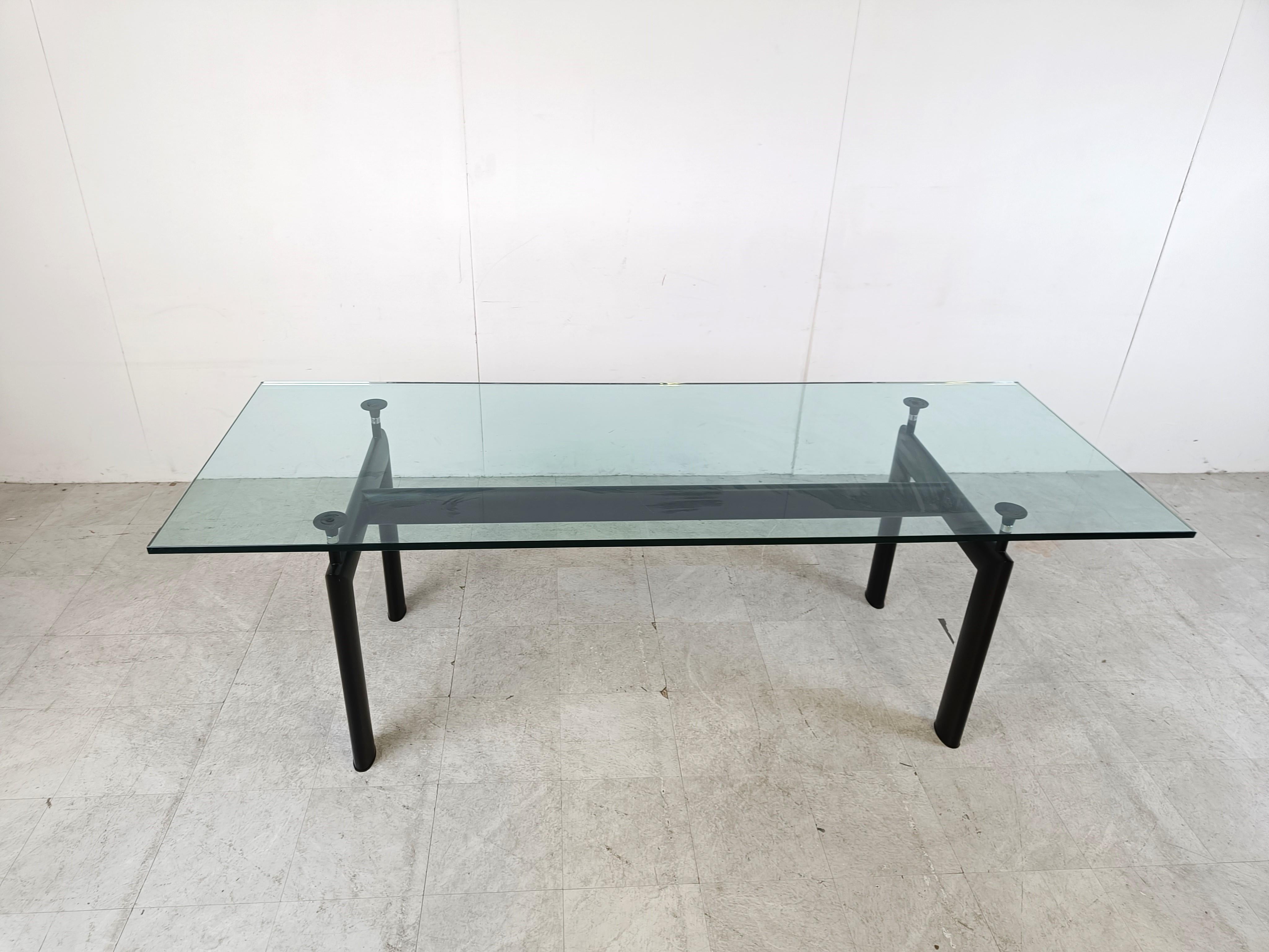 Table de salle à manger conçue par Le Corbusier, Pierre Jeanneret, Charlotte Perriand à l'origine en 1928 pour le Salon d'Automne à Paris et relancée en 1974 par Cassina.

Elle se compose d'une base en aluminium noir avec 4 supports réglables qui