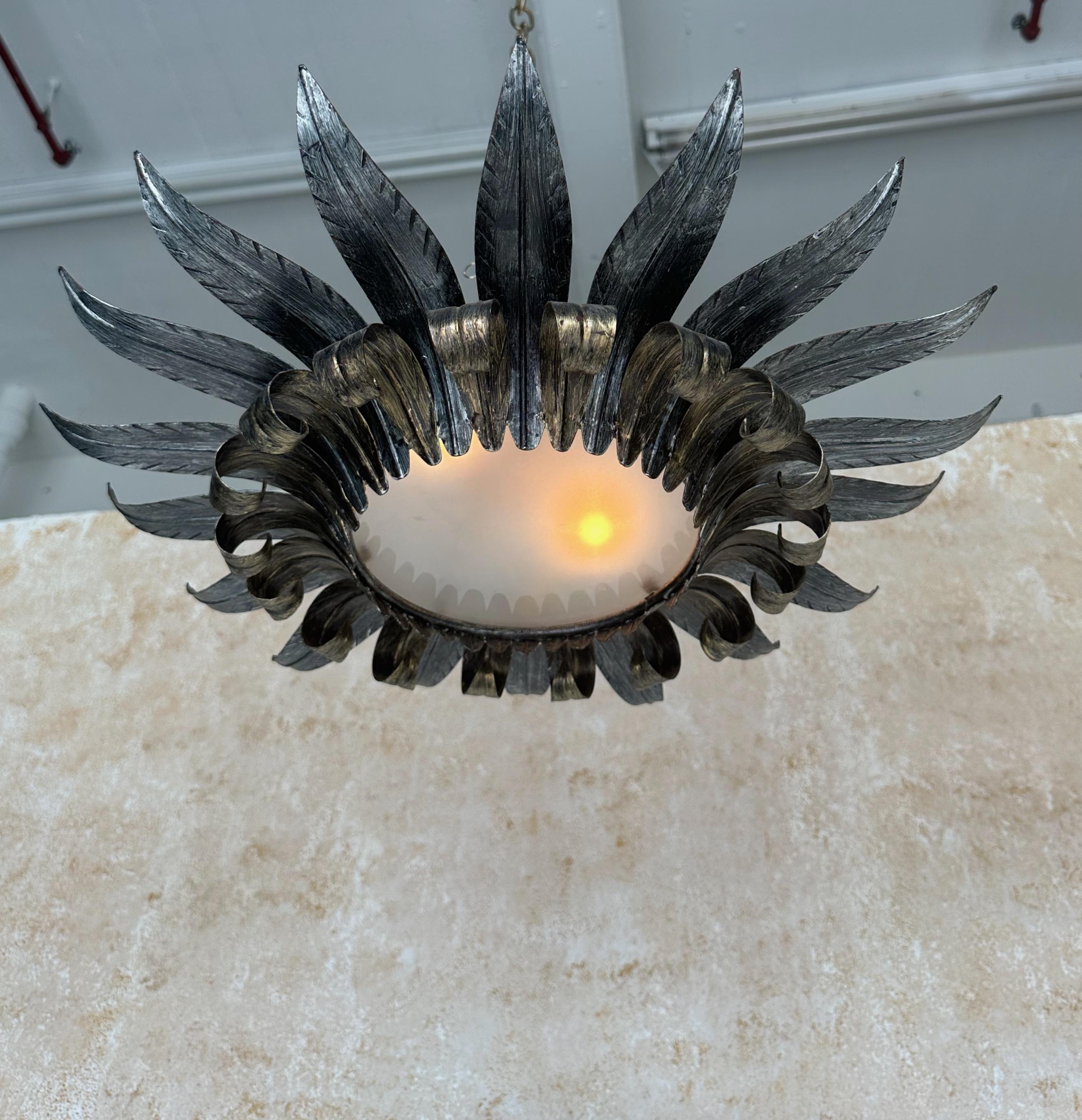This elegant 1950s Spanish flush mount ceiling fixture features a double tiered leaf design. The upper tier leaves are silvered, and curl slightly upward, offering a contrast to the darker gold lower leaves which curve gracefully at the top and
