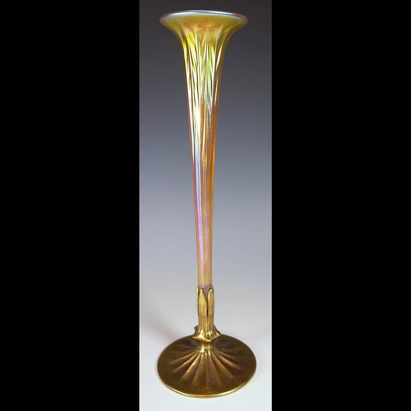 Presenting this genuine Louis Comfort Furnaces trumpet vase with gold washed and enameled bronze sleeve base. The vessel is made from iridescent 