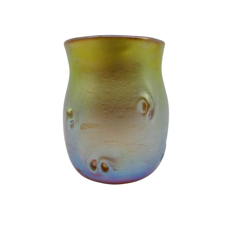 Offering this diminutive Louis Comfort Tiffany gold Favrile iridescent art glass cordial glass that may also be used as a toothpick holder / shot glass. This cordial features a rounded body with 