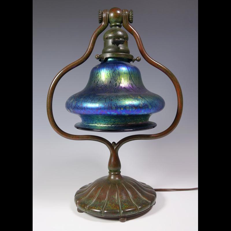 Presenting this exceptional Tiffany Studios “harp” lamp made from patinated bronze and features a blue iridized 