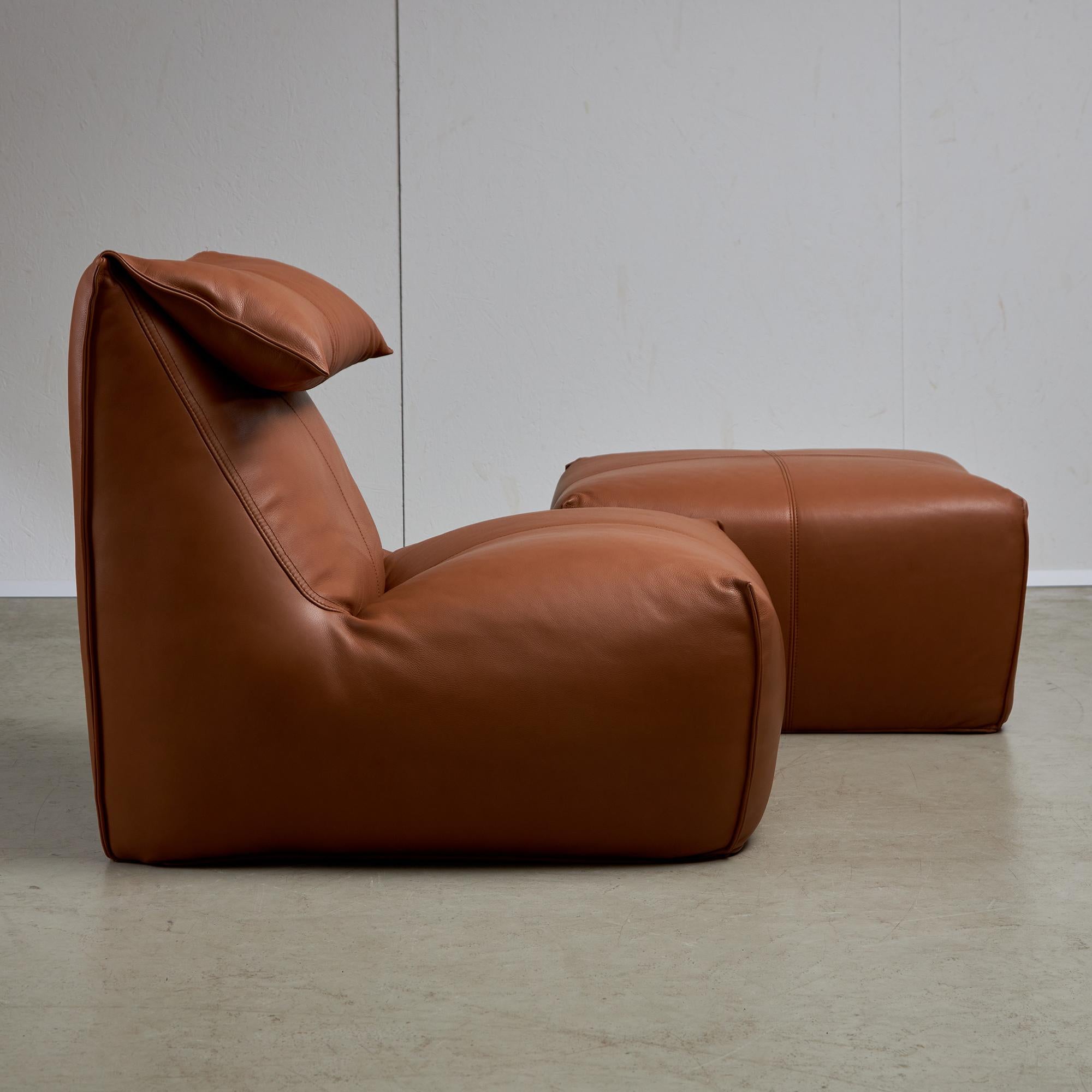 Robust, coffee-brown sponge and leather lounge chair with folding backrest and with a footrest. The Le Bambole lounge chair by Mario Bellini provides a feeling of deep comfort and relaxation. It was designed for B&B Italia in 1972. Available in