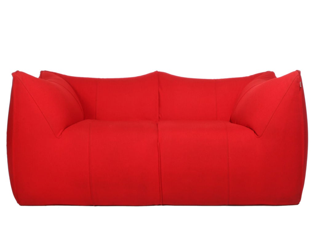 A Le Bambole settee by Mario Bellini with peaked corners, retaining the original red wool fabric. 

Designed by Mario Bellini for B&B Italia, the design was inspired by a filled shopping bag that was shaped when the bag was set on the ground and