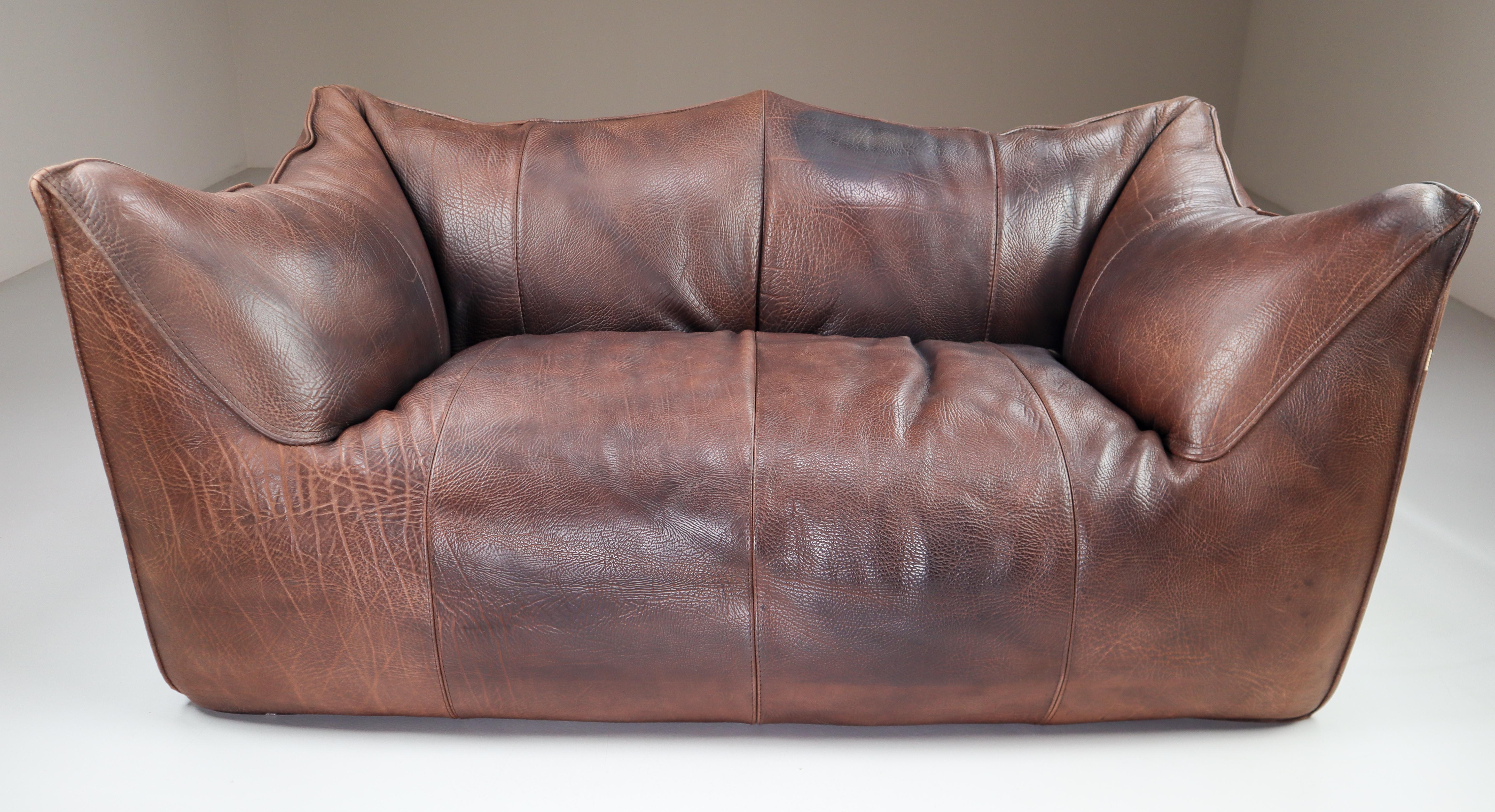 Original patinated neck leather two-seat sofa “Le Bambole” by Mario Bellini for B & B Italia. Manufactured in Italy during the 1970s. Really comfortable sofa in original thick chocolate neck leather. Almost 50 years old, but the sofa remains in good