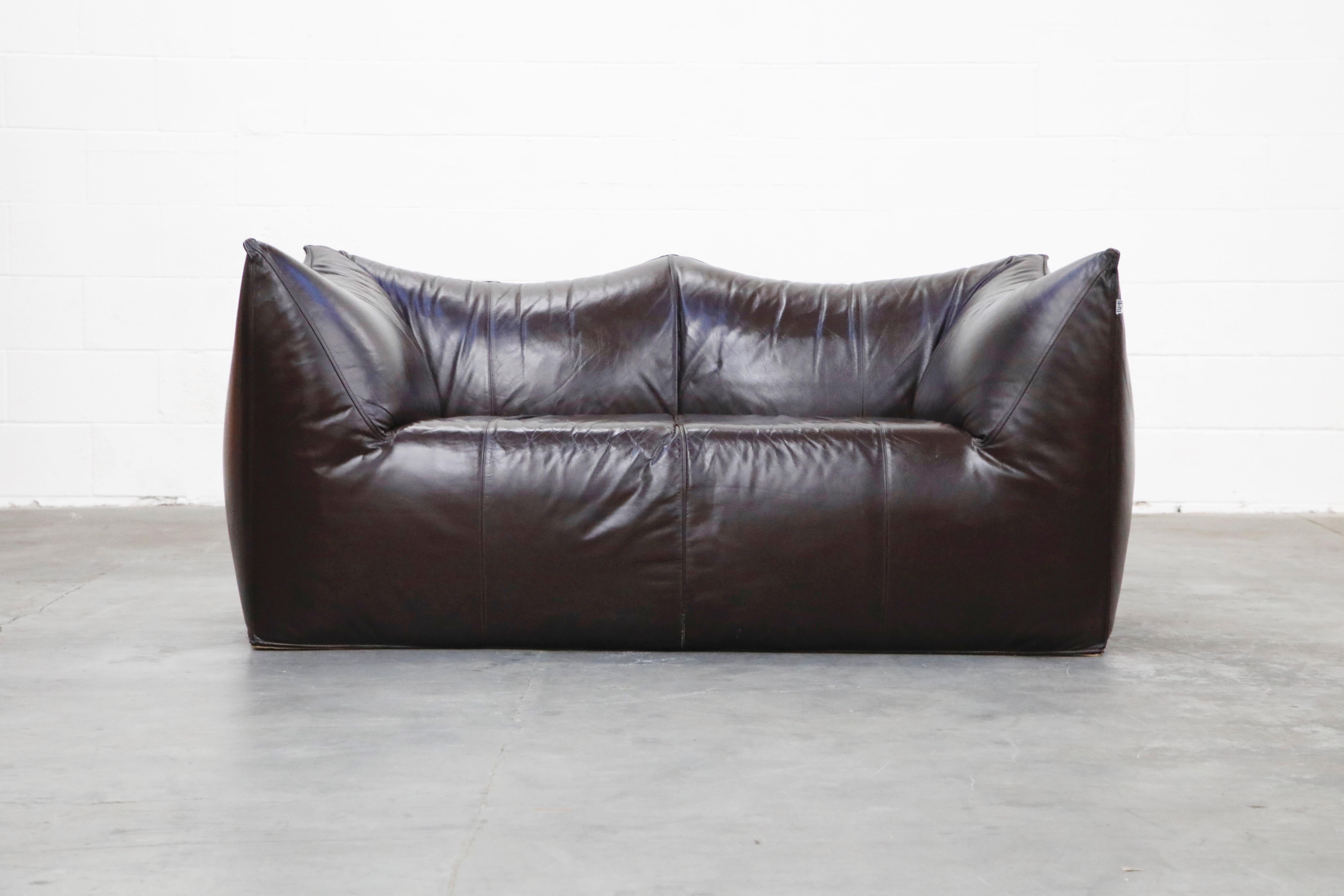 This incredible 'Le Bambole' loveseat by Mario Bellini for B&B Italia has thick gorgeous dark brown hide leather. The color is a dark deep brown that it looks black in lower light settings and beautiful dark brown in brighter settings. Designed in