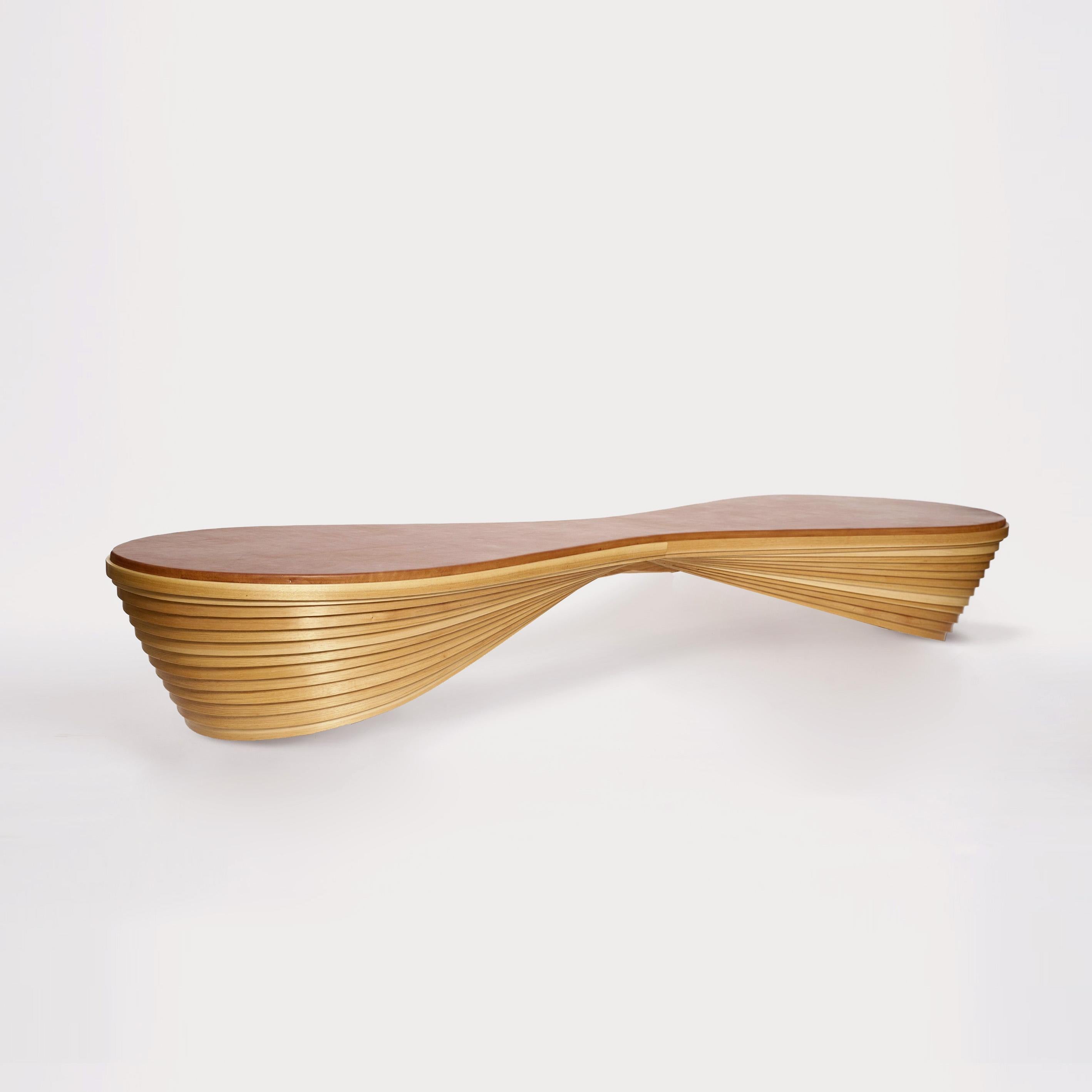 Le Bench is a steam-bent hickory bench. The bent hoops, inspired by Le Nid, are assembled in a tight overlapping stack, topped with a leather cushion, and mounted on hidden metal legs.