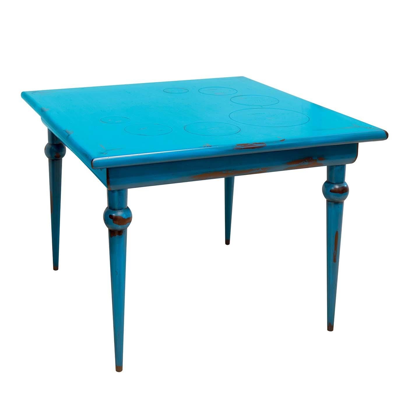 Bursting with a vivid cobalt blue color, this striking dining table is a practical and versatile piece of functional decor. Fashioned of Toulipier walnut and Tanganica veneer, the square top is decorated with the engraved circle of bubbles