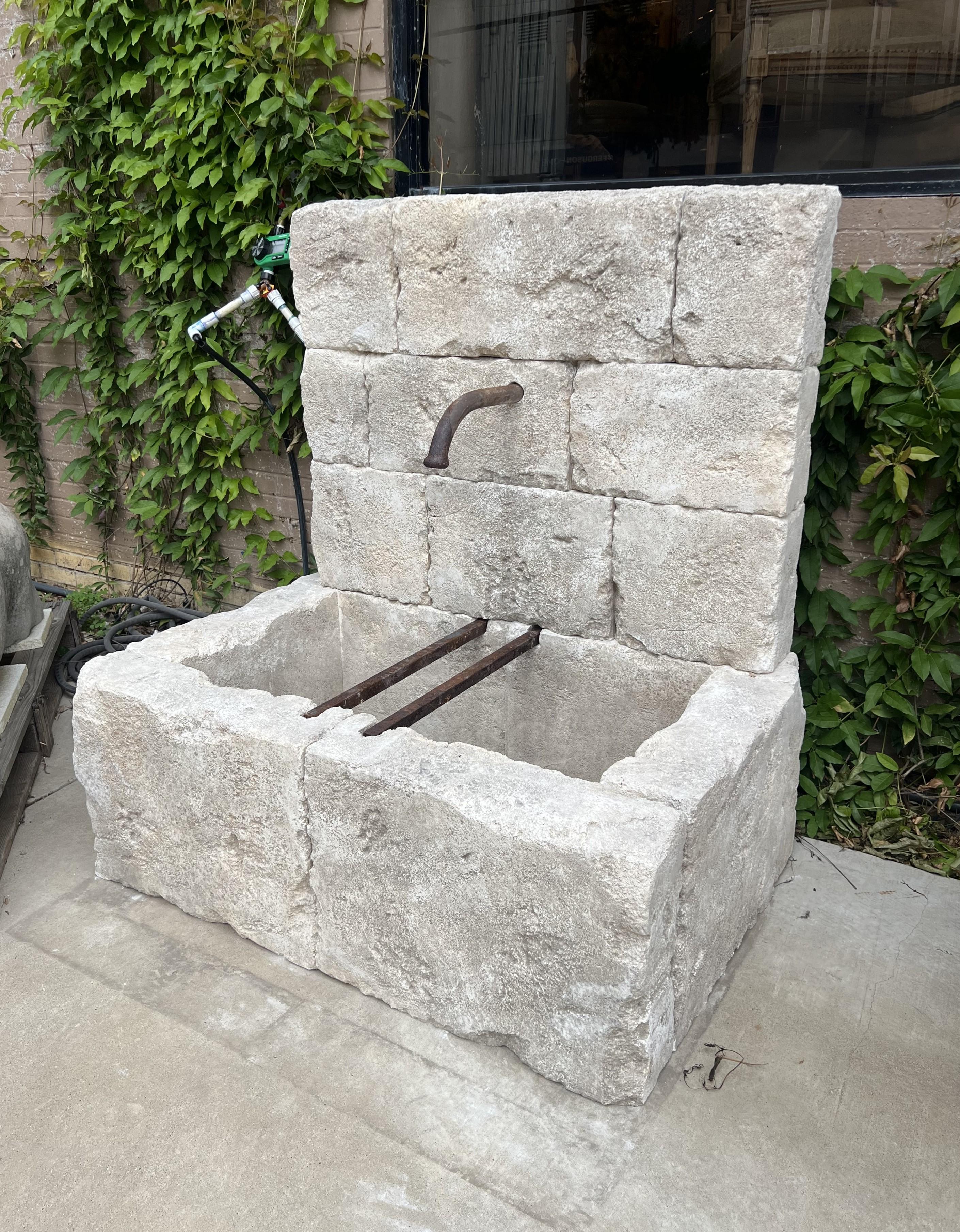 More information coming soon…

Hand-carved in the South of France, this wonderfully distressed wall fountain consist of 15 pieces of limestone blocks.  The rectangular back wall houses an iron spout that is positioned over the rectangular basin. 