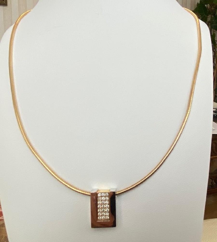 Offered in good condition, 18 kt bi-color pendant from the world famous brand Le Chic on an omega necklace of 14 kt gold. The pendant and the necklace are marked JR+4. The pendant is equipped with 21 brilliant cut diamonds of approximately 0.24 crt