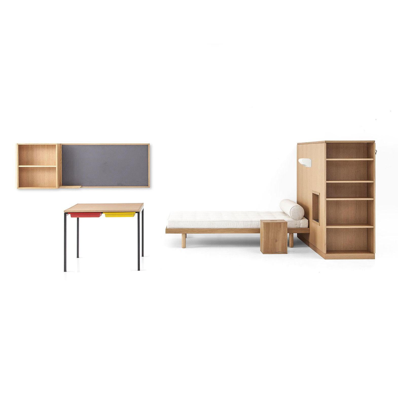 Reproduction of a student room in the Maison du Brésil, a set of a wardrobe-room divider, a bed, a desk, the Maison du Bresil stool and a wall-hung bookcase and blackboard. Set designed by Le Corbusier and Charlotte Perriand in 1959. Relaunched in