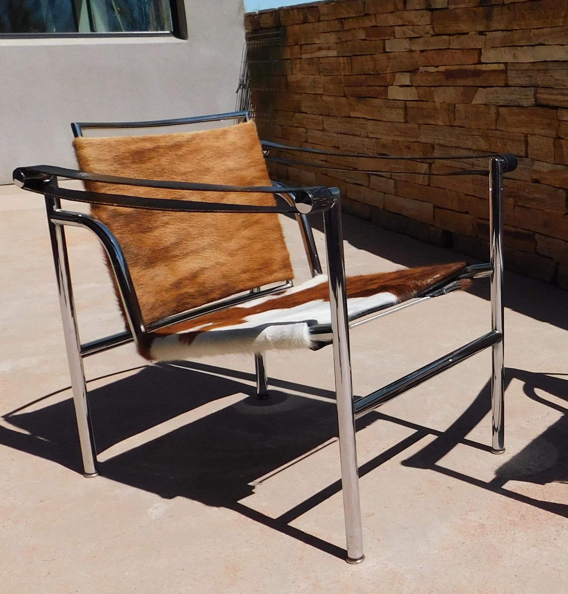 Par de  Sillas LC/1 diseñadas por Le Corbusier, Pierre Jeanneret, Charlotte Perriand en 1928. Relanzada en 1965. Fabricado por Cassina en Italia. Cada silla mide 25,2 de alto x 23,63 de ancho x 25,6 de fondo. La barra trasera de una silla tiene