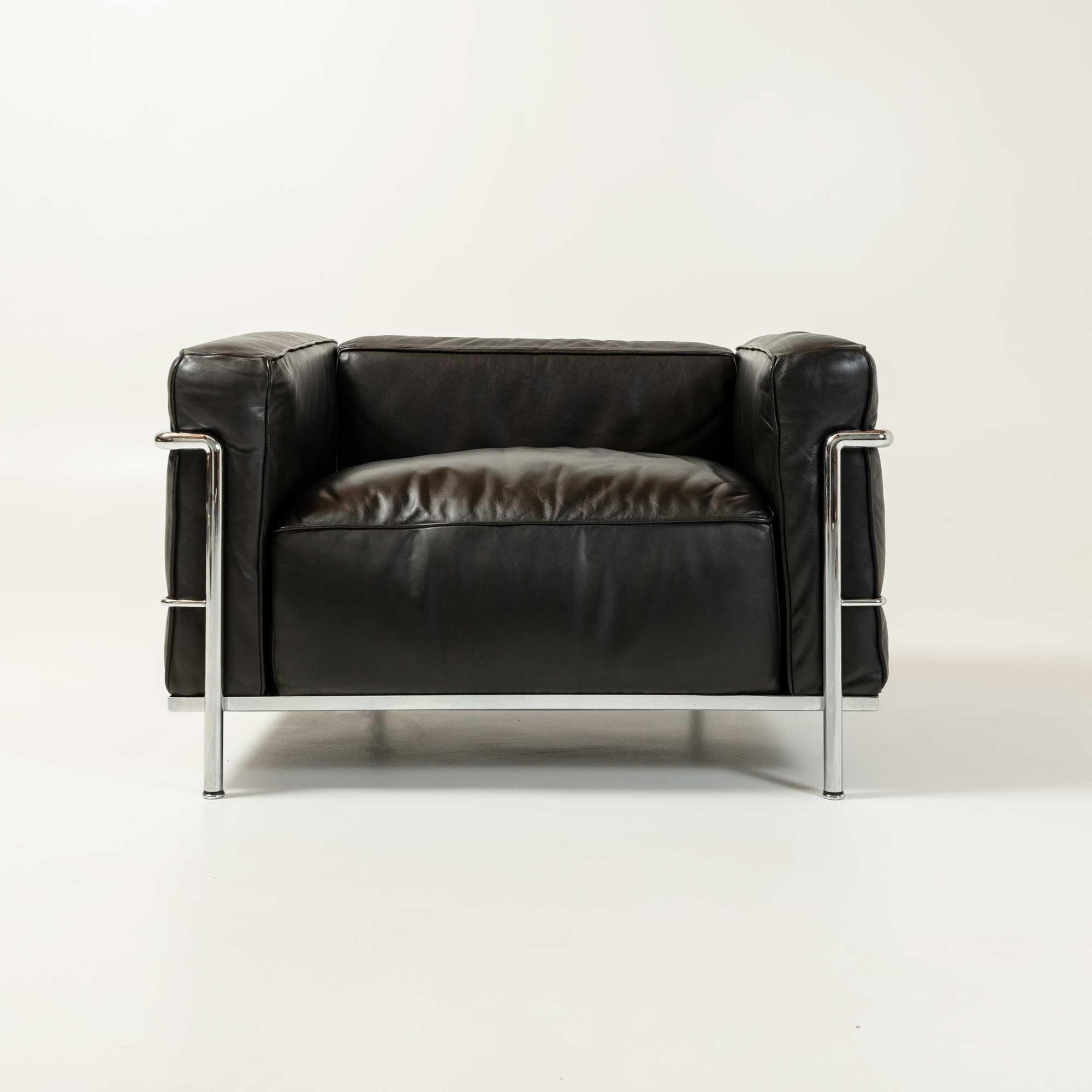 Iconic Bauhaus design by the Swiss-born architect Le Corbusier (Charles-Edouard Jeanneret) are the LC2 and LC3 armchairs. 
This vintage Fauteuil Grand Confort, or LC3 Lounge Chair, features original restored black leather cushions and a chrome