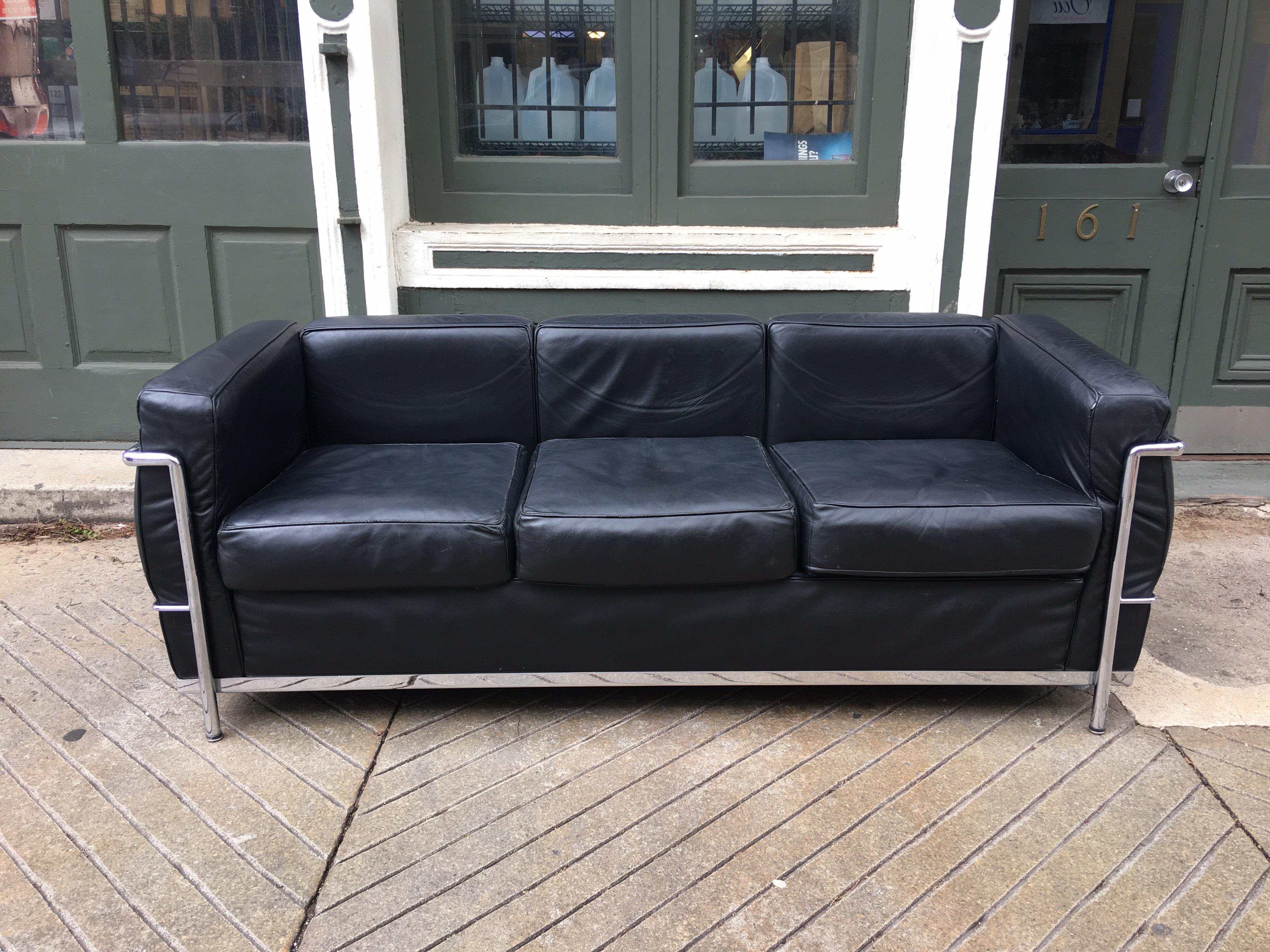 Italian made Le Corbusier LC-2 sofa in black leather. Probably 15-20 years old this Italian made sofa looks pretty good! Chrome is perfect and leather shows some wear mostly on piping, with one spot as seen in photos where the piping is broken.