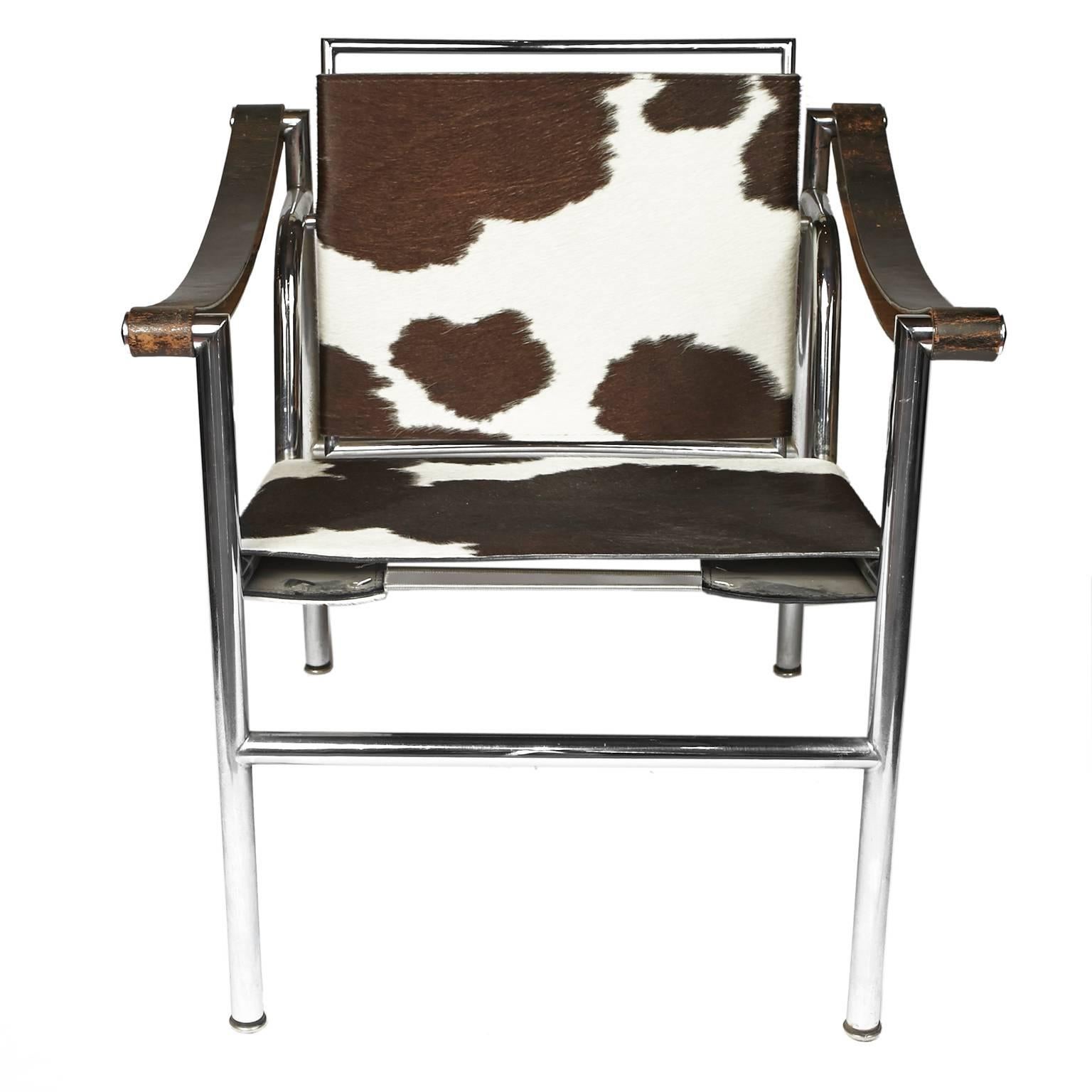Le Corbusier LC1 cow hide sling chairs. Good vintage condition with wear to arms and some pitting to chrome. Marked on bottom Le Corbusier LC/1 0845 on one chair and Le Corbusier LC/10849 on the other chair. One chair is primarily black and white,