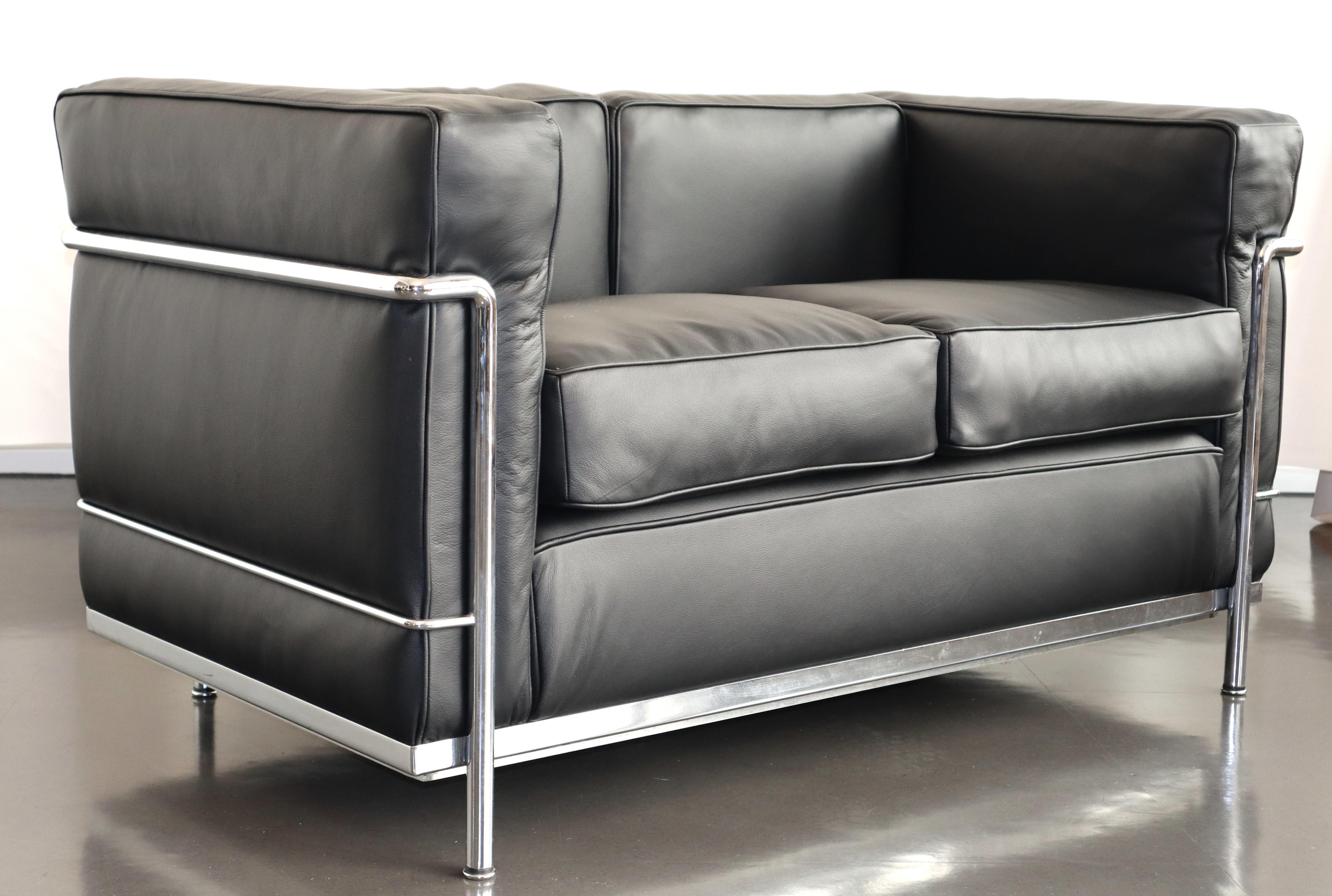 Timelessly iconic Le Corbusier LC2 two-seater sofa in chrome tube steel and black leather. Made in Italy by Cassina. Signed with serial number.

The LC2 was designed in 1928 by Le Corbusier; his cousin and colleague Pierre Jeanneret; and Charlotte