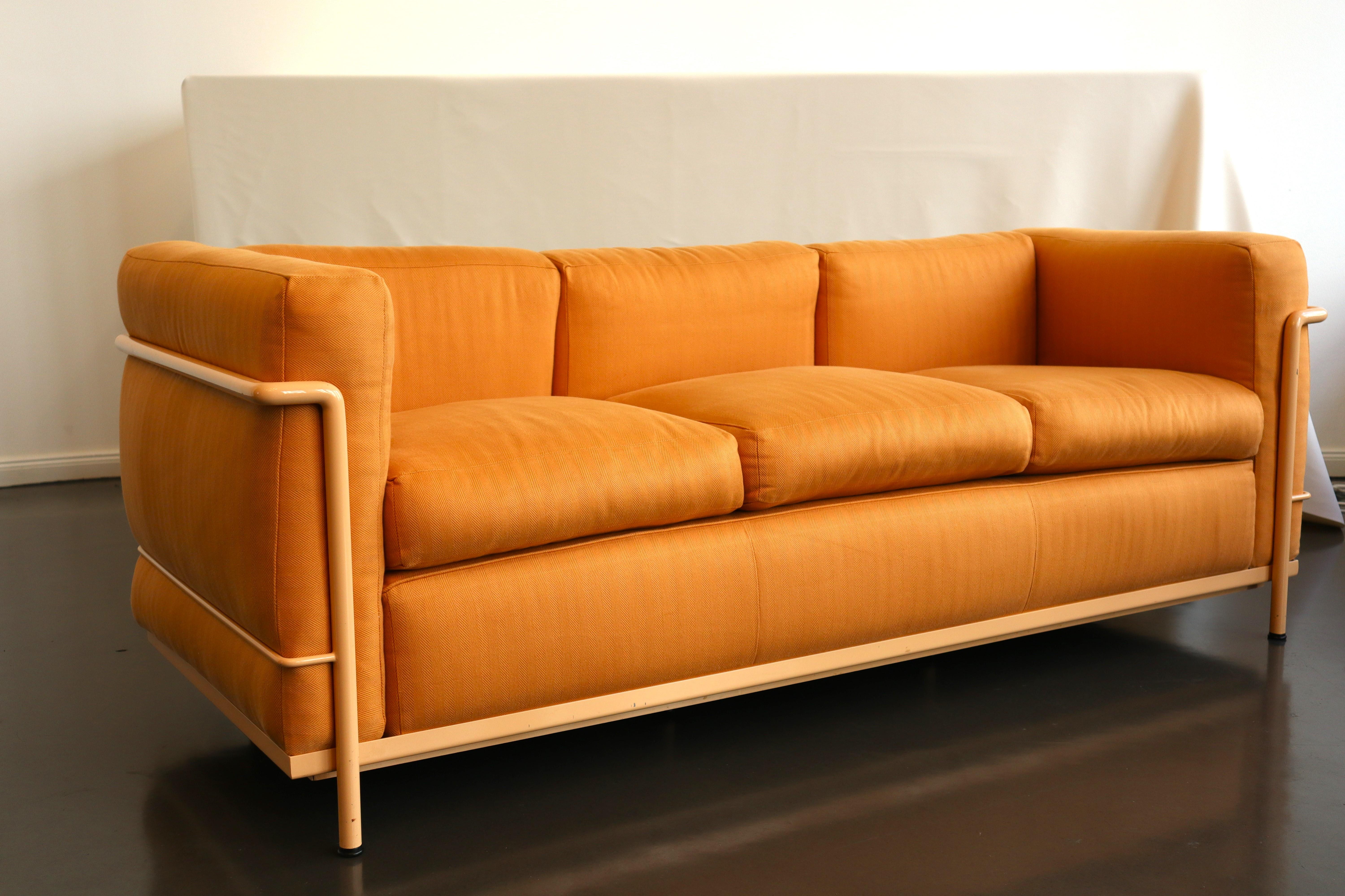 Timelessly iconic Le Corbusier LC2 three-seater sofa in peach tube steel and herringbone-patterned mango leather. Made in Italy by Cassina. Signed with serial number.

The LC2 was designed in 1928 by Le Corbusier; his cousin and colleague Pierre