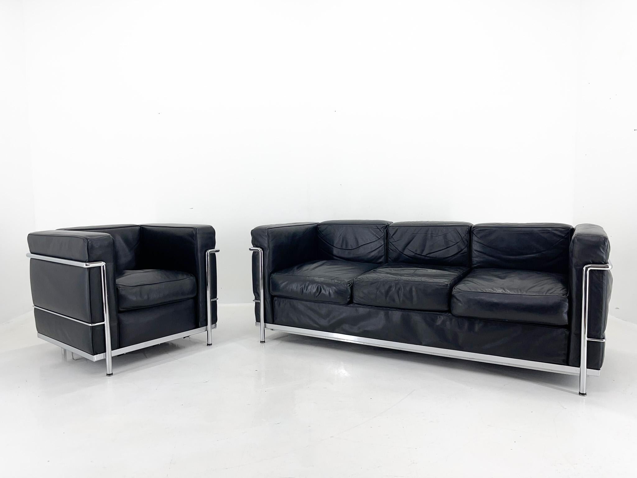 Three-seater sofa and armchair in black leather and chrome, made at the end of the 20th century. Based on the LC3 sofa designed by Le Corbusier, Pierre Jeanneret and Charlotte Perriand for Cassina. A fantastic combination of comfort and modern