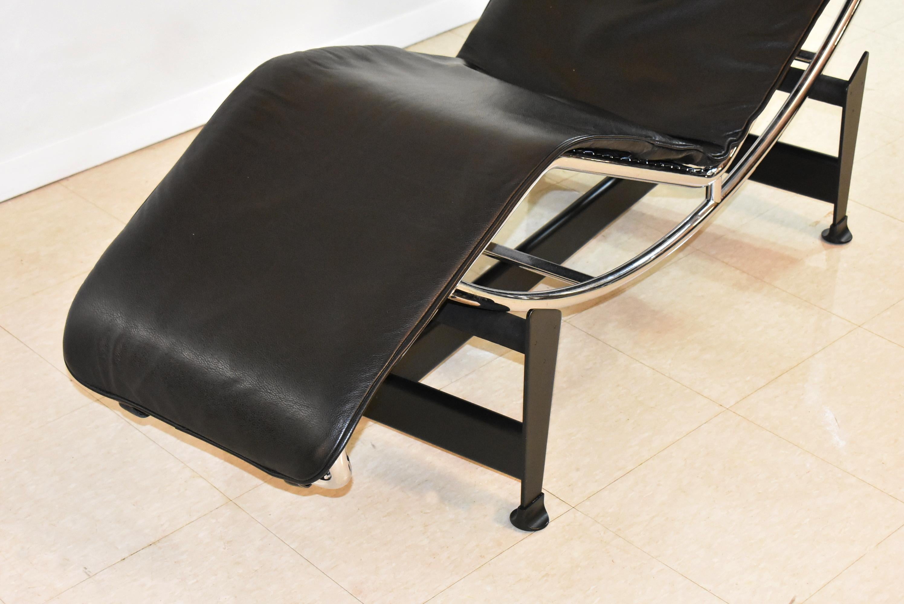 Le Corbusier LC4 chaise lounge by Cassina featuring a black leather pad and headrest on a tubular chrome and black finished steel base. The 
