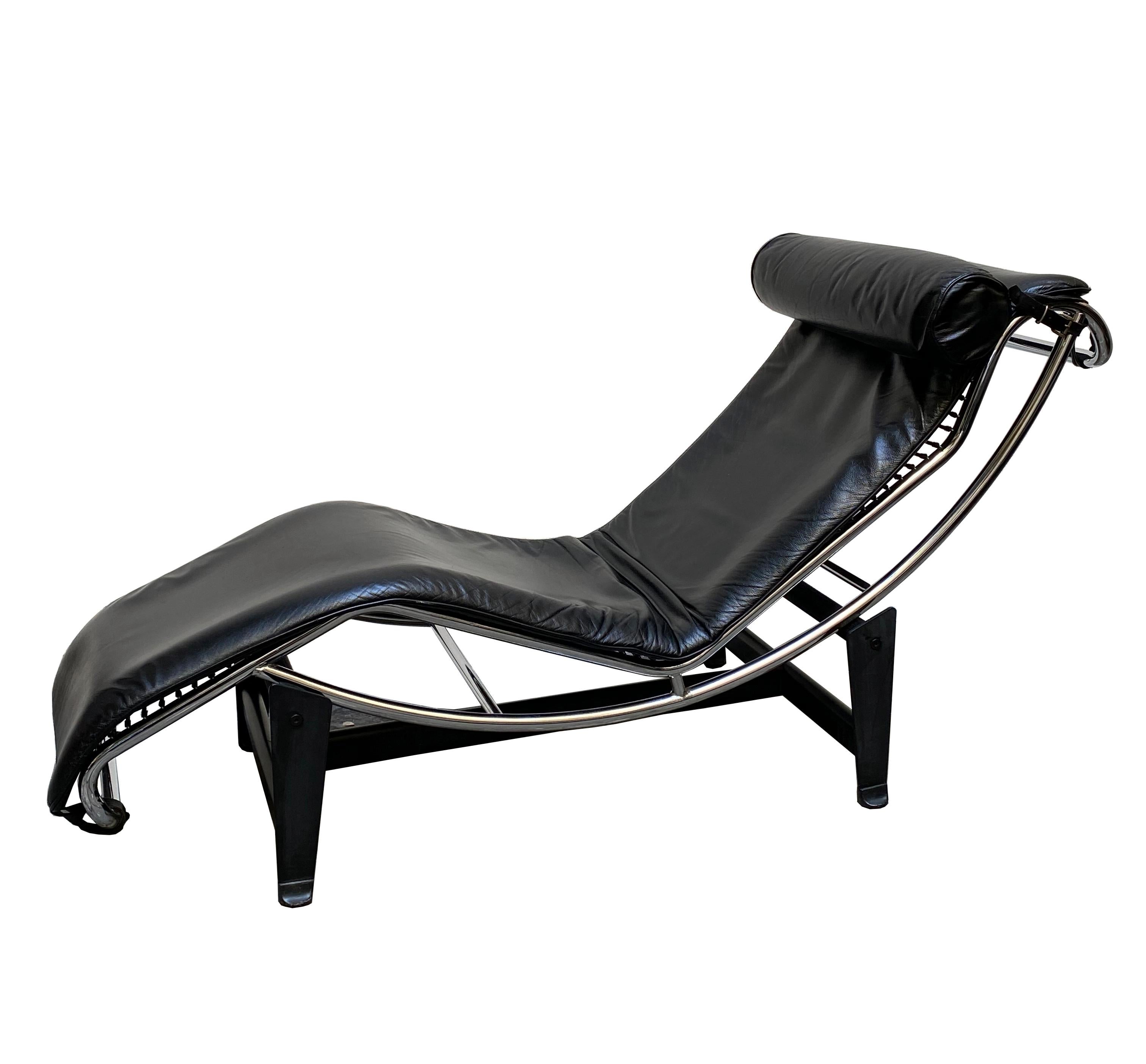 This LC4 lounge chair with black steel base, adjustable shiny chromed metal tubular structure, seat and headrest in black leather is made in the style of Cassina. It is in perfect condition. LC4 is the definitive chaise longue: built in a form