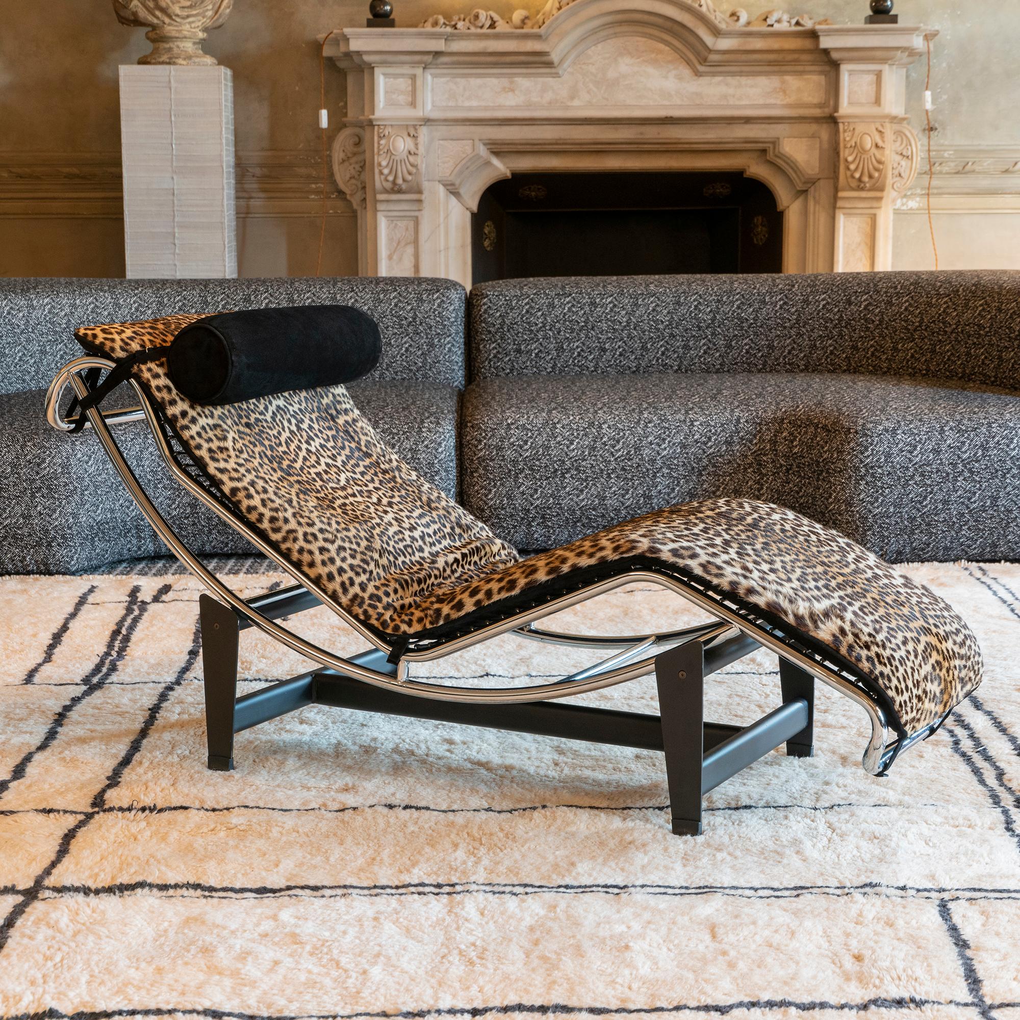 Lounge chair in the style of the Le Corbusier LC4, (the base is not signed and numbered like the original one by Cassina), original vintage leopard skin with vintage patina and perfect condition, the back black suede and headrest cushion are newly