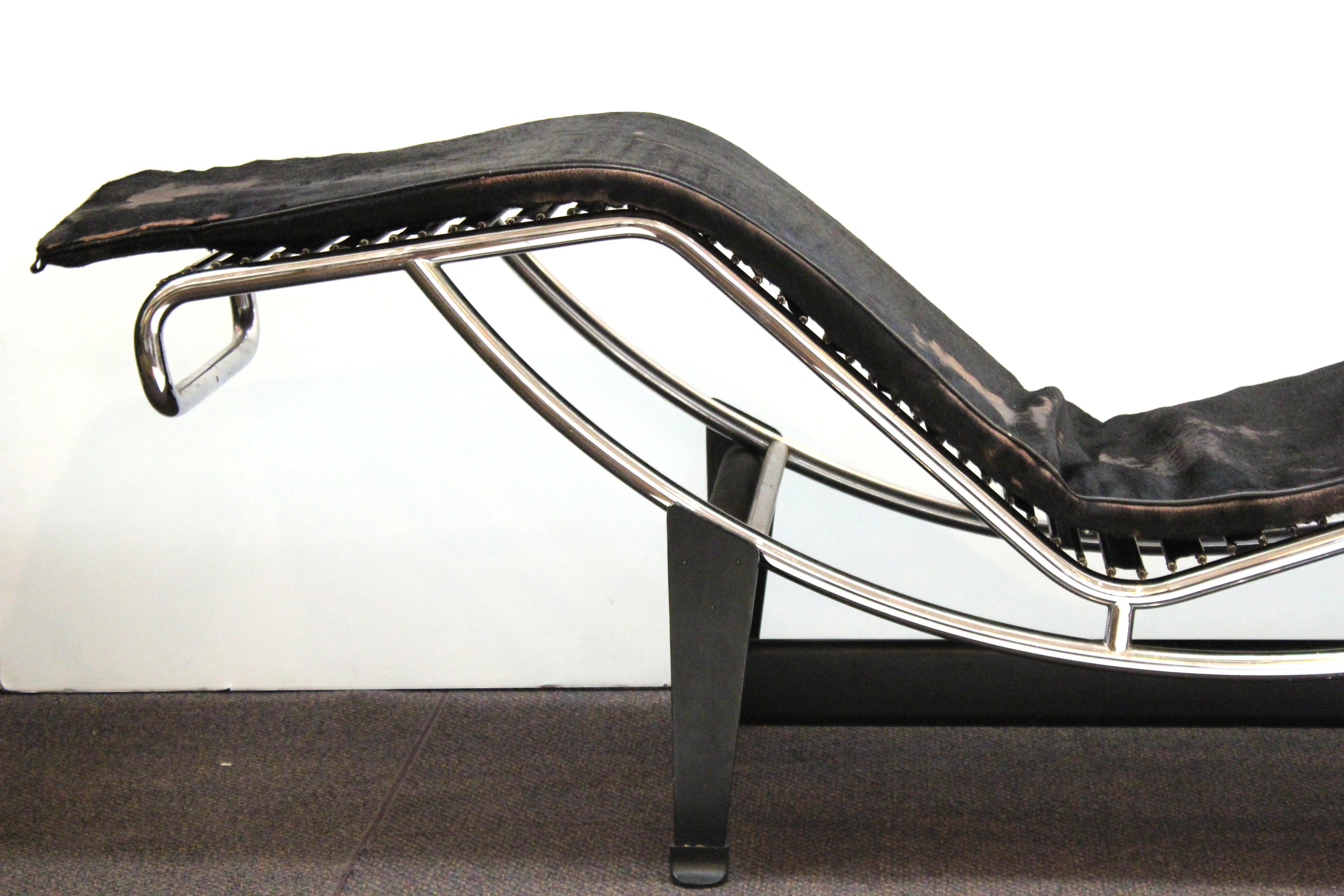 Modernist LC4 iconic chaise lounge or daybed, originally designed by Le Corbusier in the 1920s. The piece has its original leather cushioning and pillow. Age-appropriate wear to the leather surfaces and to the pillow. The structure is in great