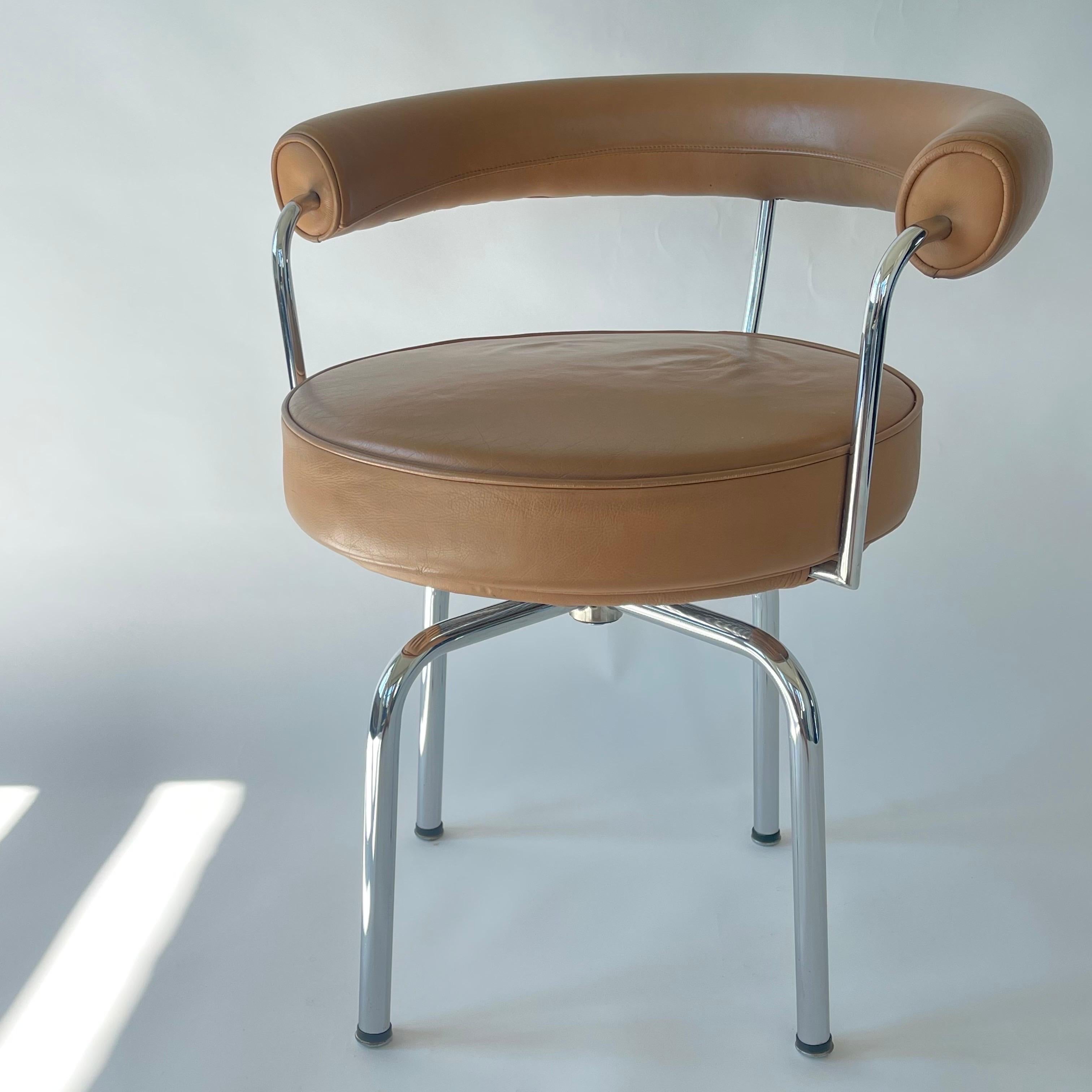 Iconic LC7 Swivel armchair rendered in a chrome plated tubular steel frame with cognac leather upholstery.  Designed by Le Corbusier, Charlotte Perriand, and Pierre Jeanneret for Cassina, Italy, 1970s.  Early version, unmarked.