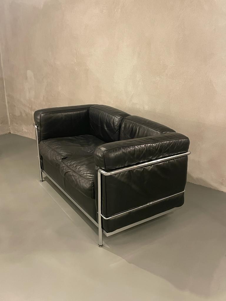 Mod. Lc2 sofa designed by Le Corbusier, Pierre Jeanneret, Charlotte Perriand for Cassina in Italy, 1970.
Sofa has two leather seats and has a tubular chrome frame.
Under the seat cushions and on the underlying coating of cushions is repeated logo