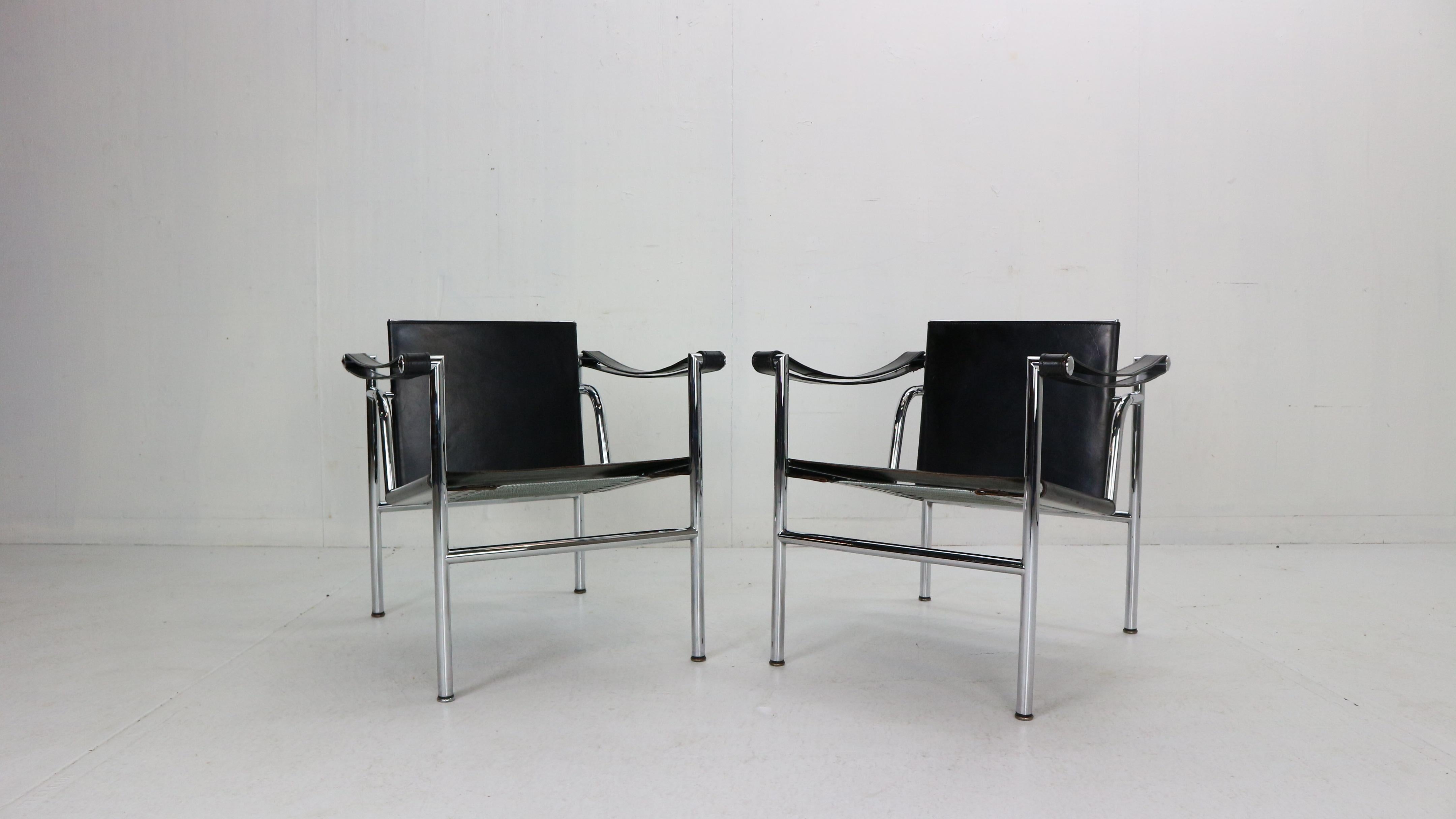 Set of 2 armchairs designed by Le Corbusier and manufactured for Cassina, famous Italian furniture manufacture in 1970s period.
Both chairs are original signed. 
Model number- LC1.
Chrome tubular frame and black original leather seating.
The