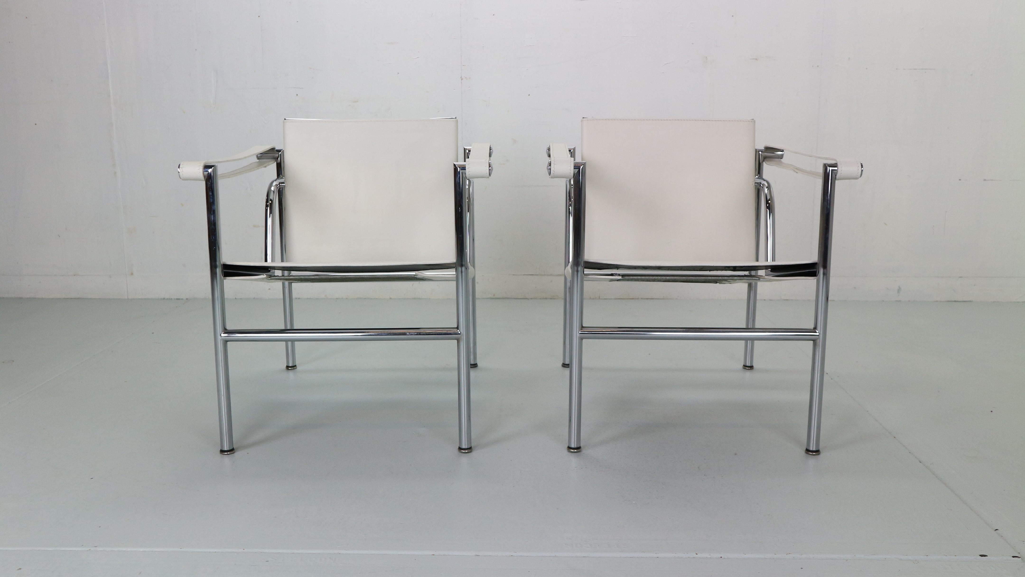 Set of 2 armchairs designed by Le Corbusier and manufactured for Cassina, famous Italian furniture manufacture in 1970s period.
Both chairs are original signed, low number early edition. 
Model number- LC1.
Chrome tubular frame and white original