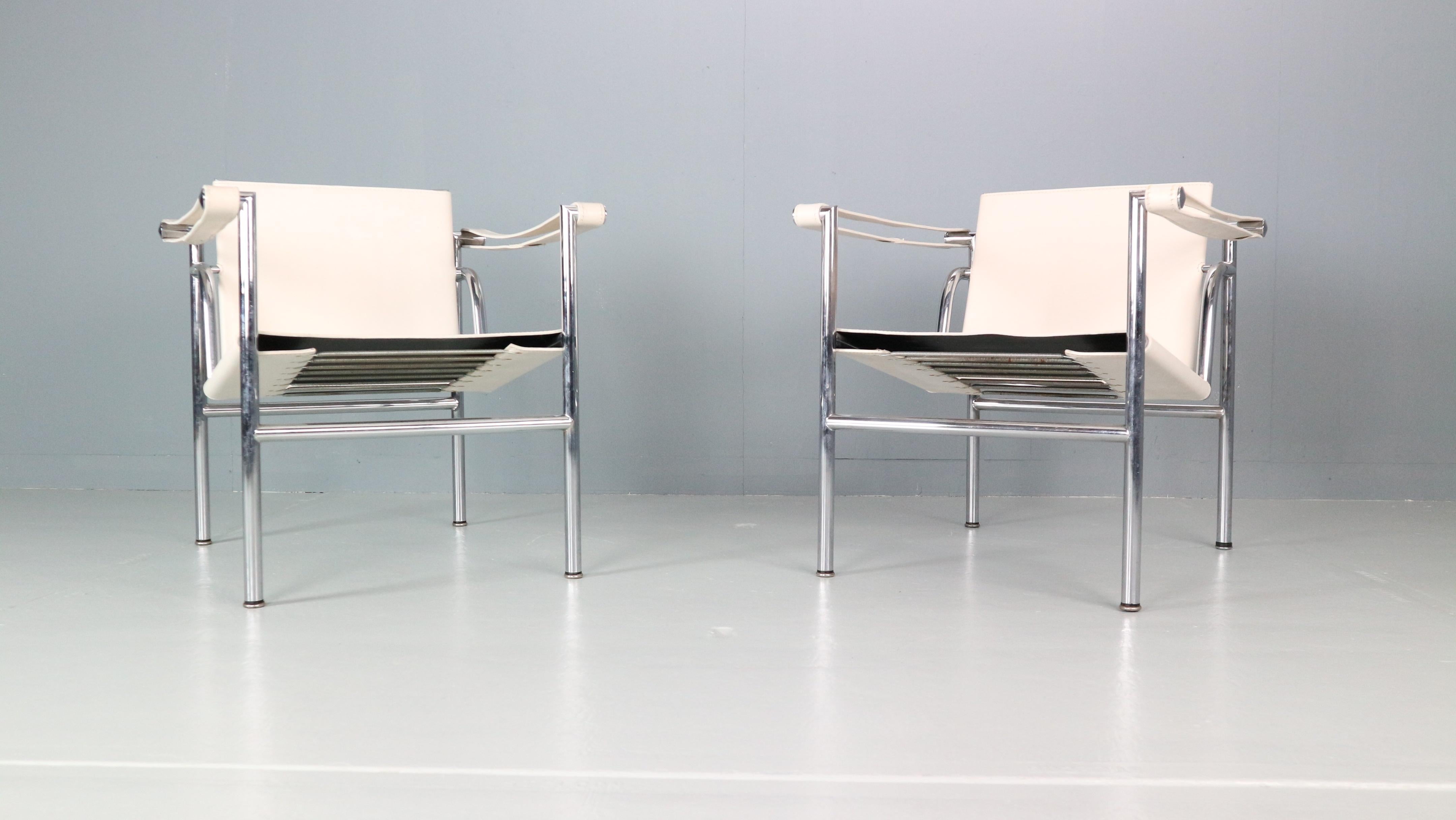 Set of 2 armchairs designed by Le Corbusier and manufactured for Cassina, famous Italian furniture manufacture in 1970s period.
Both chairs are original signed, low number early edition. 
Model number- LC1.
Chrome tubular frame and white original