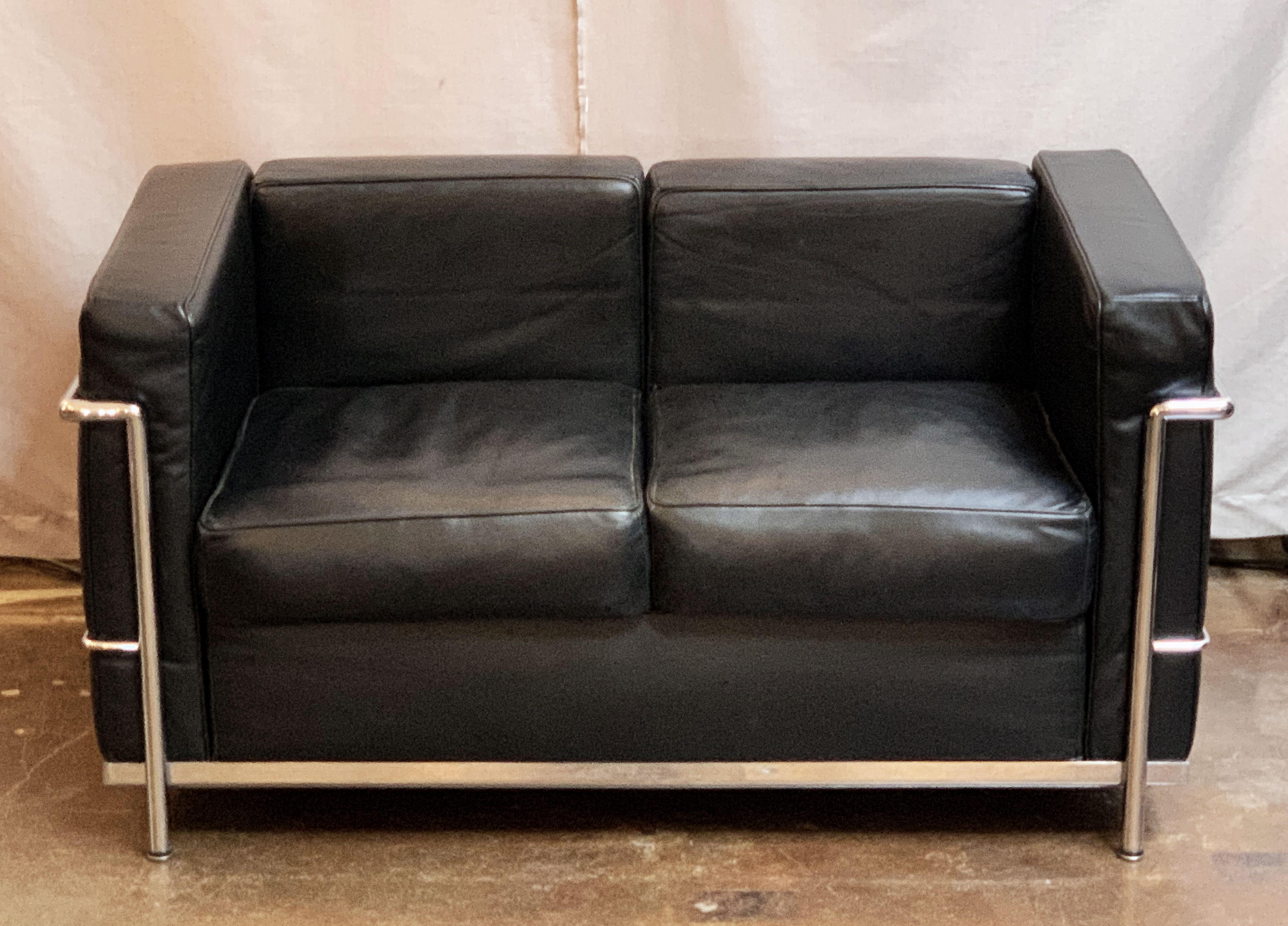 A fine vintage black leather sofa, featuring the stylish chrome frame and black leather upholstered cushions made famous by Le Corbusier, Pierre Jeanneret and Charlotte Perriand in their work for Cassina. Offering comfortable seating and modern