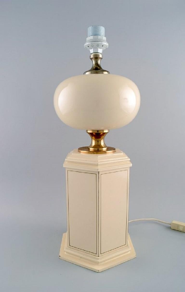 Le Dauphin, France. Large table lamp in cream lacquered metal and brass. 
1970s.
Measures: 48 x 19 cm (ex socket).
In excellent condition.