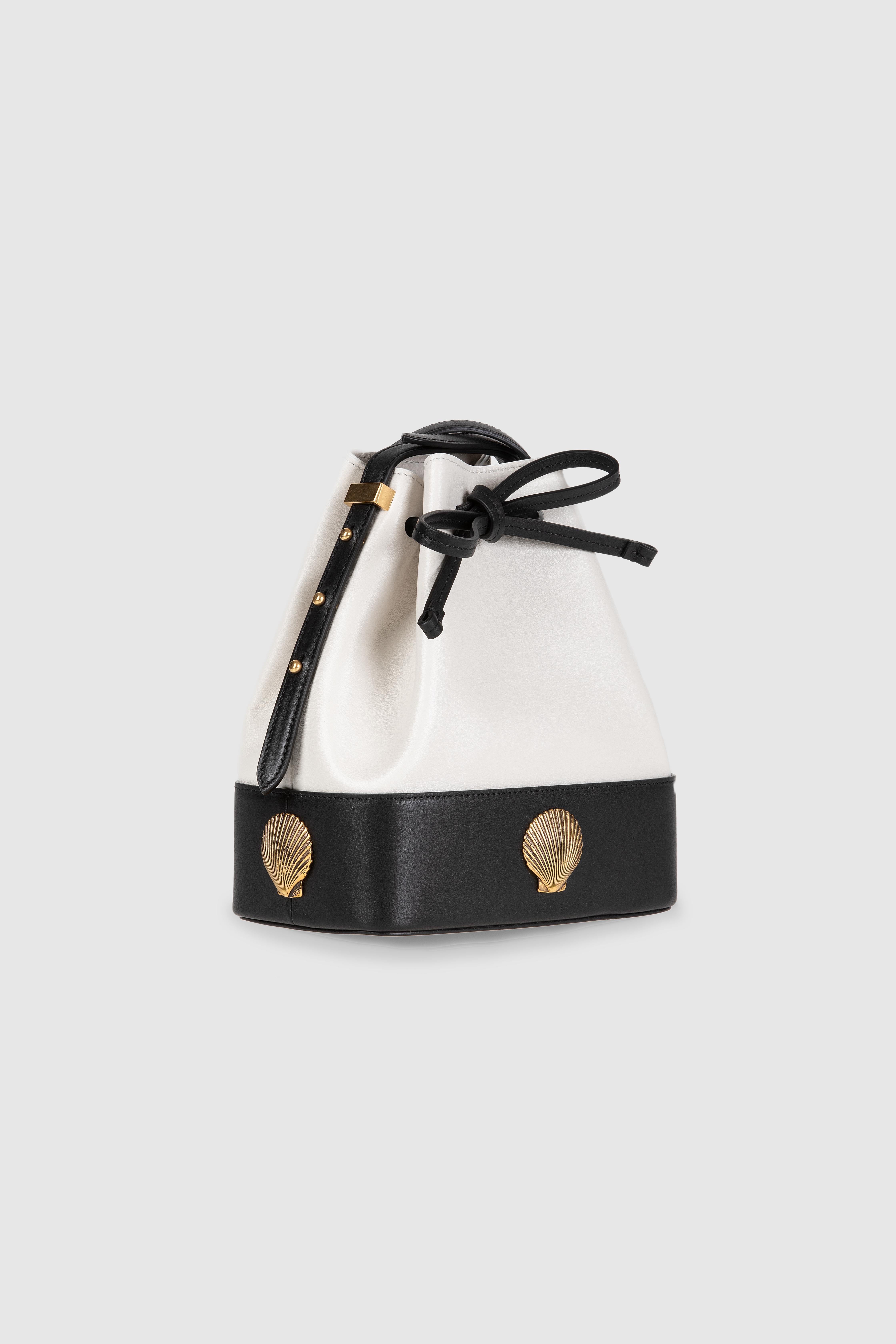 Bucket small bag in calfskin leather with adjustable shoulder strap. Gold vintange inspired shell decorations. 
Measurements: 19 w * 21 h * 11 depth cm 
