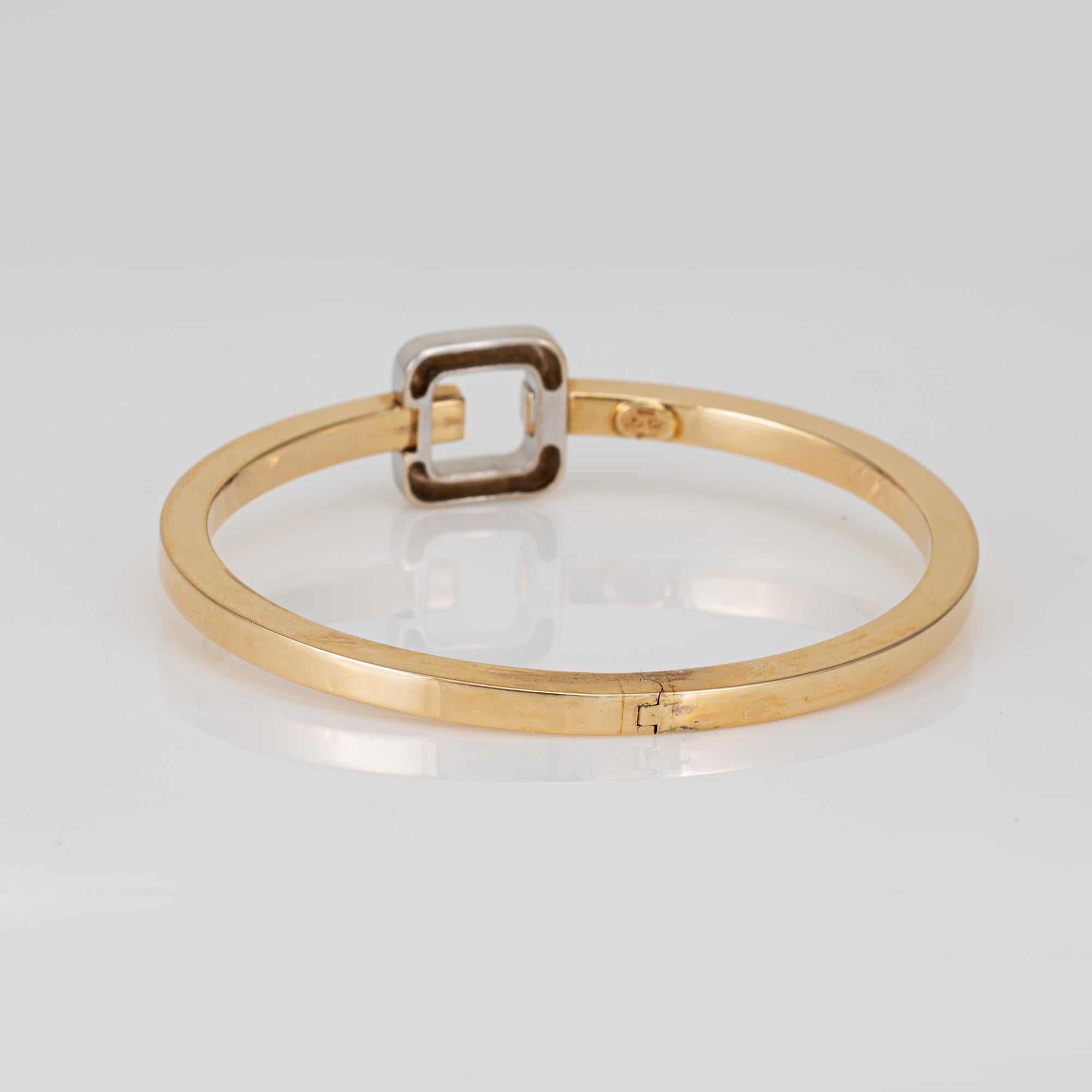 Stylish estate two-tone bangle bracelet crafted in 14 karat yellow & white gold. 

Sleek in design, the Italian made bangle easily slips on and off the wrist. Great for wear alone or stacking. 

The bracelet is in good condition and was lightly