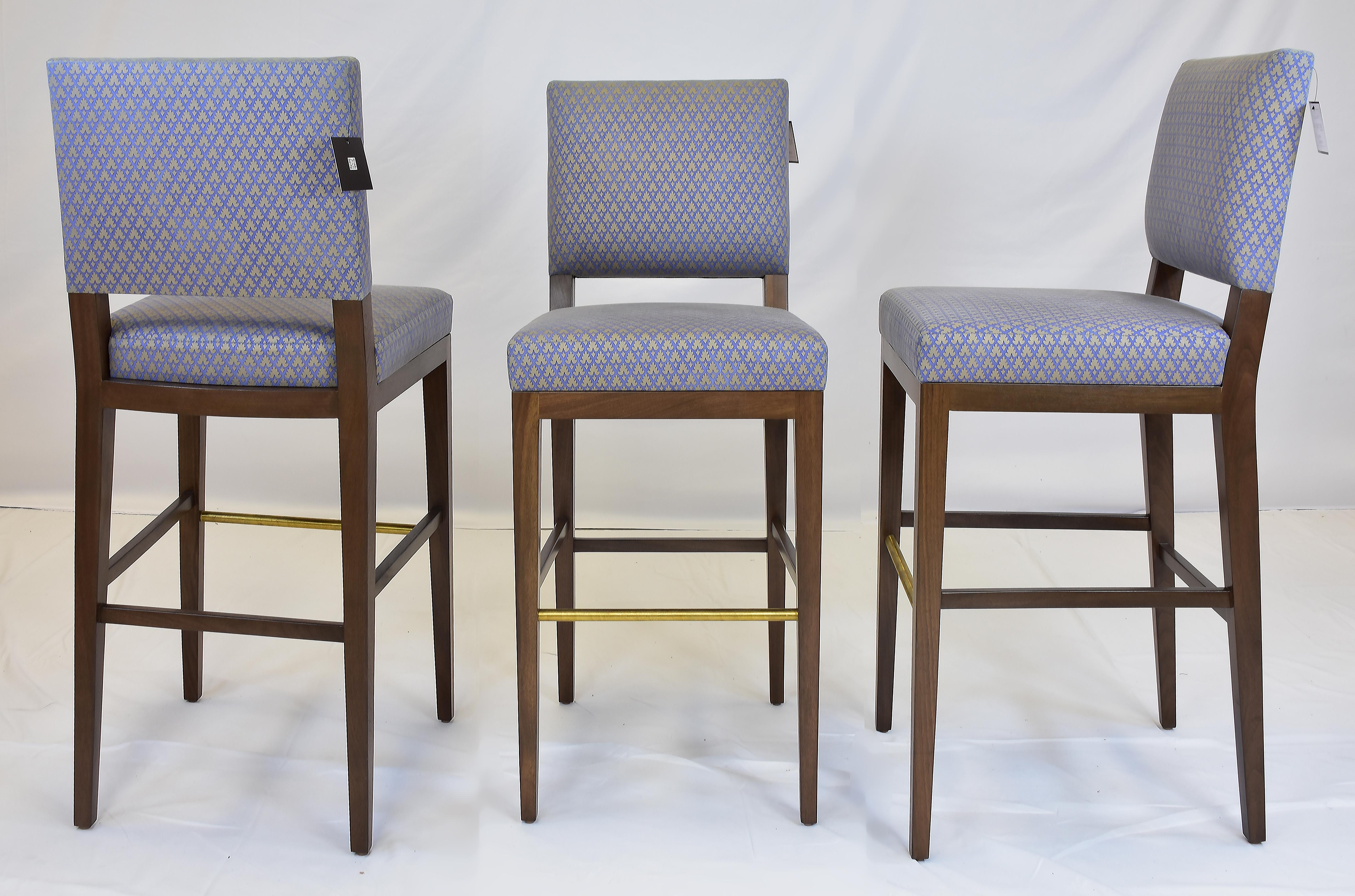 Le Jeune Upholstery Barista Barstool with Brass, Showroom Models, Per Item

Offered for sale individually are BARISTA Barstool showroom models with Brass footrests. The Barista barstools have	tight seats and backs with exposed walnut wood legs and a