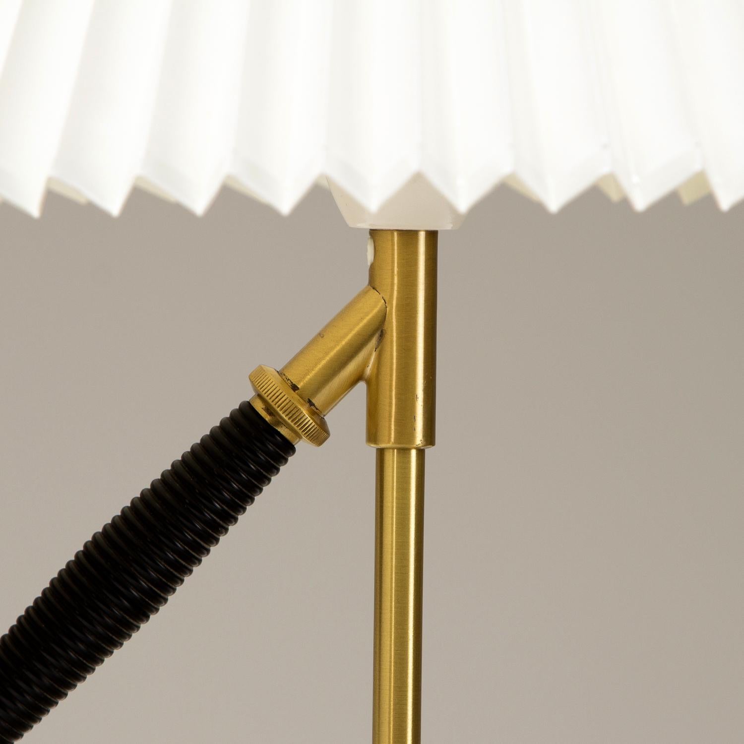 The iconic Model 306 by Kaare Klint for Le Klint. Designed in 1945 the Versatile Lamp, as it was known, can be either a table or wall lamp due to its ingenious tilting mechanism. In patinated brass with original bulb holder and switch with new Le
