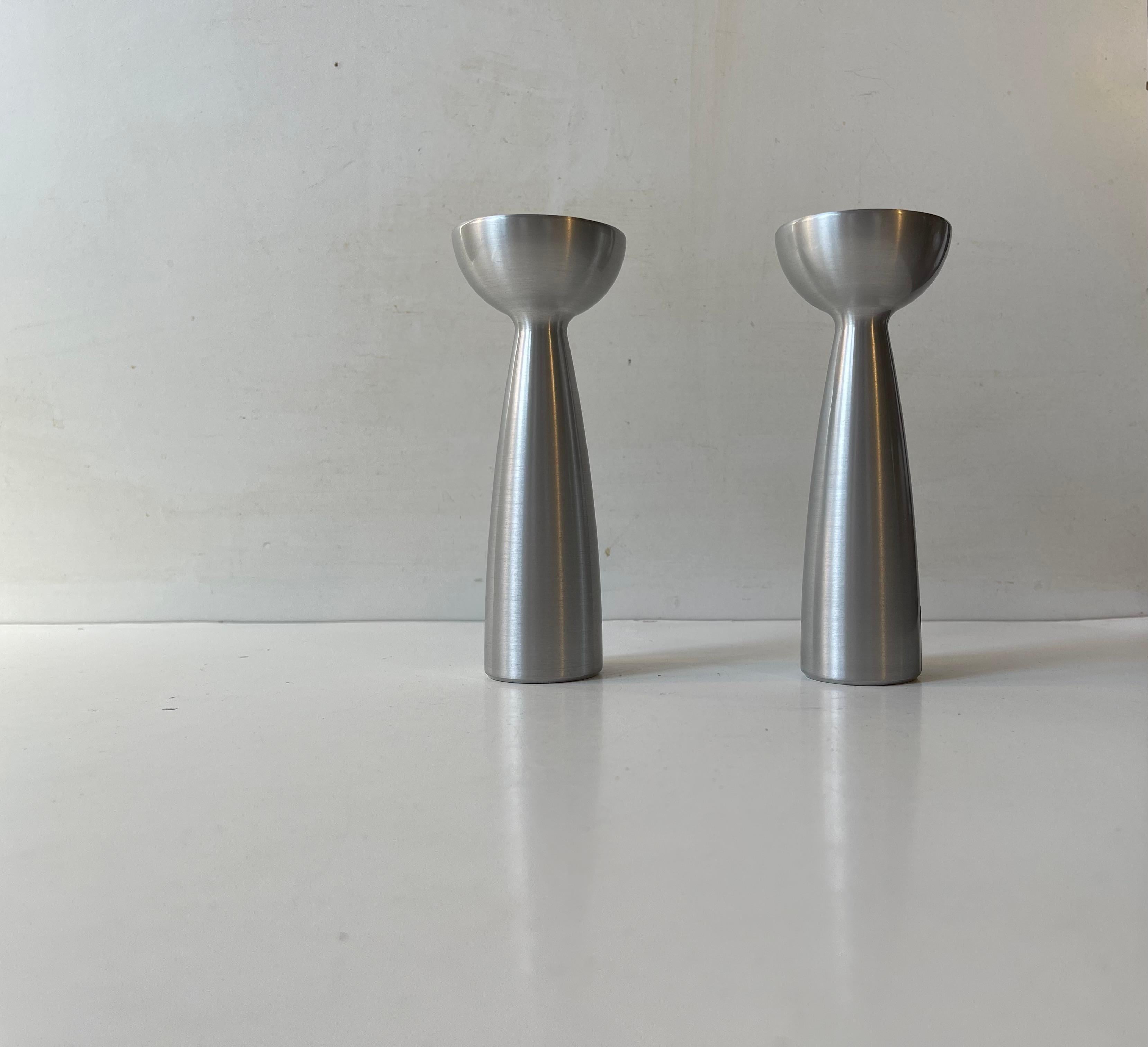 A pair of hybrid candleholders in brushed aluminum. One side takes regular sized candles and the other can be used with tea light candles. Made by Le Klint in Denmark during the 1990s. Makers marks still present. 

Measurements: H: 15 cm, Diameter: