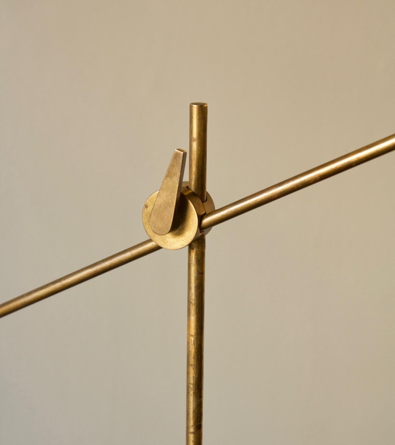 A vintage floor lamp designed and made by Le Klint in the late-1940s, Denmark, in the same period. The light is predominately made of solid brass and is complete with the original formed-aluminum shade. The cone shaped shade is lacquered in a matte