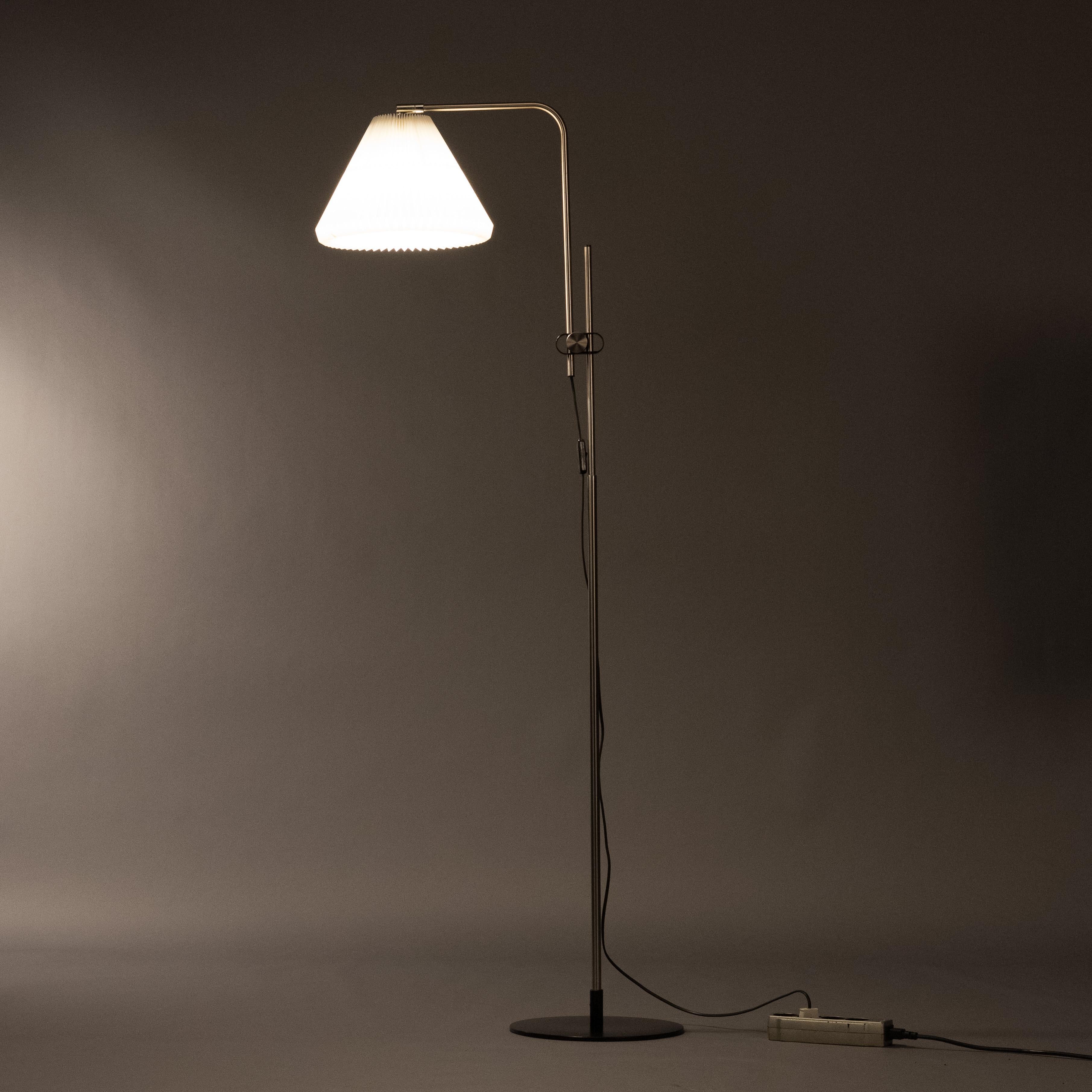 A Le Klint model 321 standing lamp designed in 1994 by Michael Bang. Full brushed steel stand and black painted steel base. Adjustable in height from 130 to 155 cm with a adjustable lamp shade. Fully original and makers sticker underneath base and