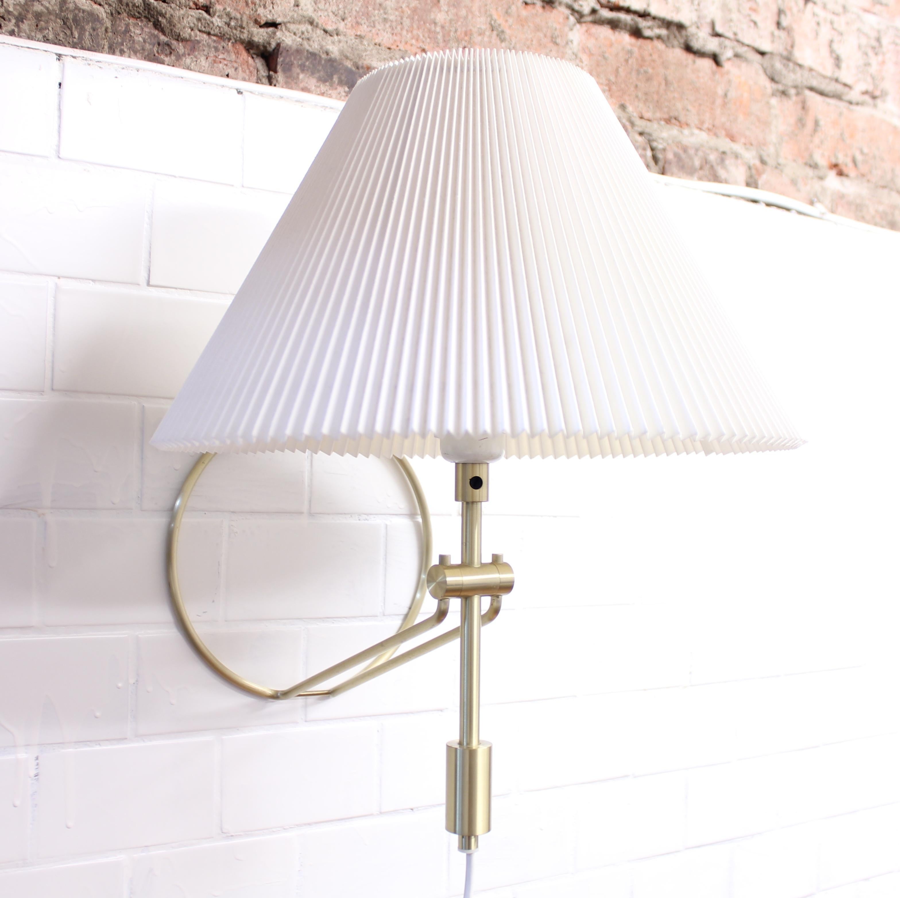Danish brass table and wall lamp, model 305, with circular base manufactured by Danish company Le Klint. Crimped paper shade, possibly a later addition but very close to the original shape and form. Marked with sticker by maker. Very good vintage
