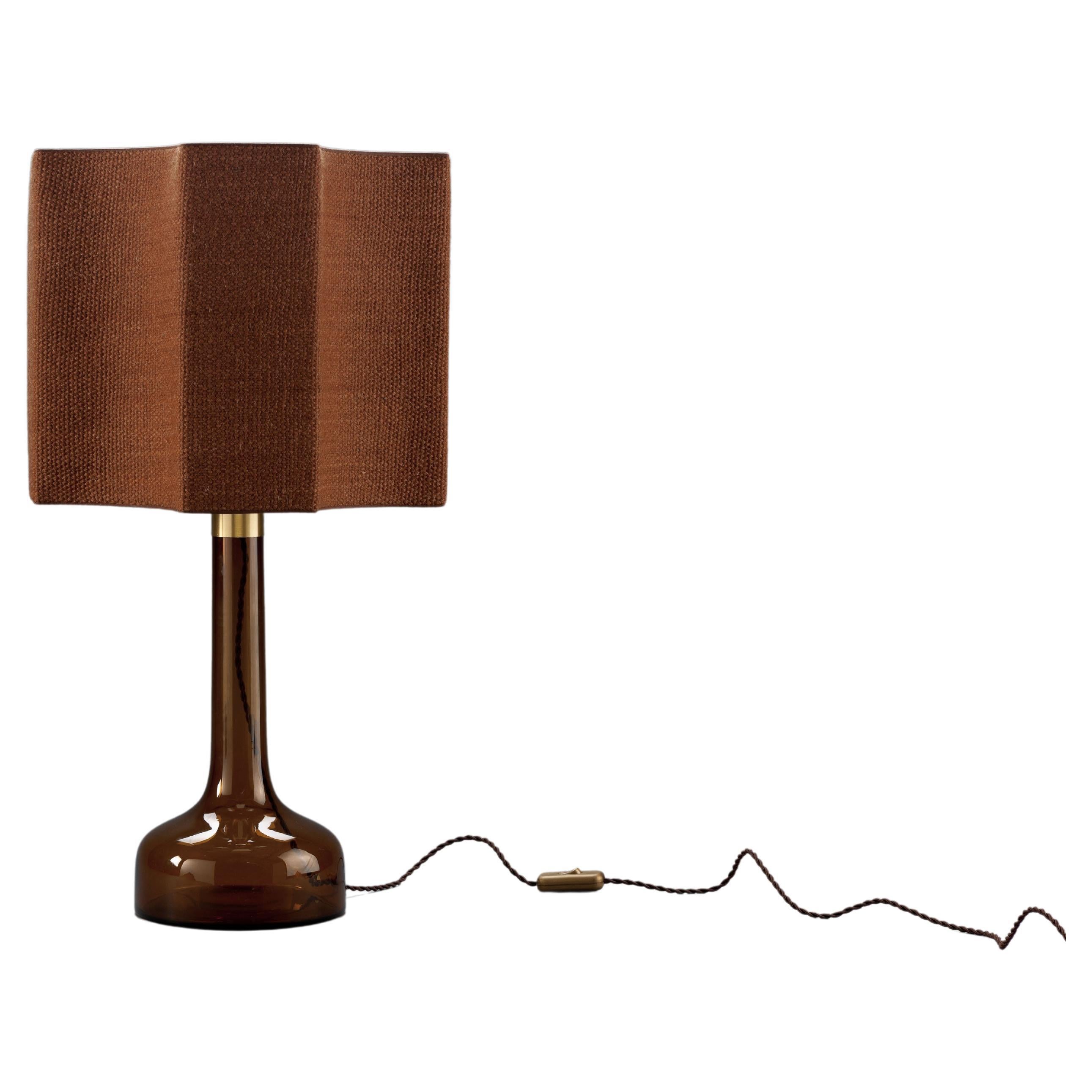 Beautiful tobacco-brown glass table lamp, mouth-blown at Holmegaard, Denmark for Le Klint, Denmark.
The special octagonal shade is a high-quality custom handmade shade, made of a hand-woven coarse fabric. The shade is gold on the inside which