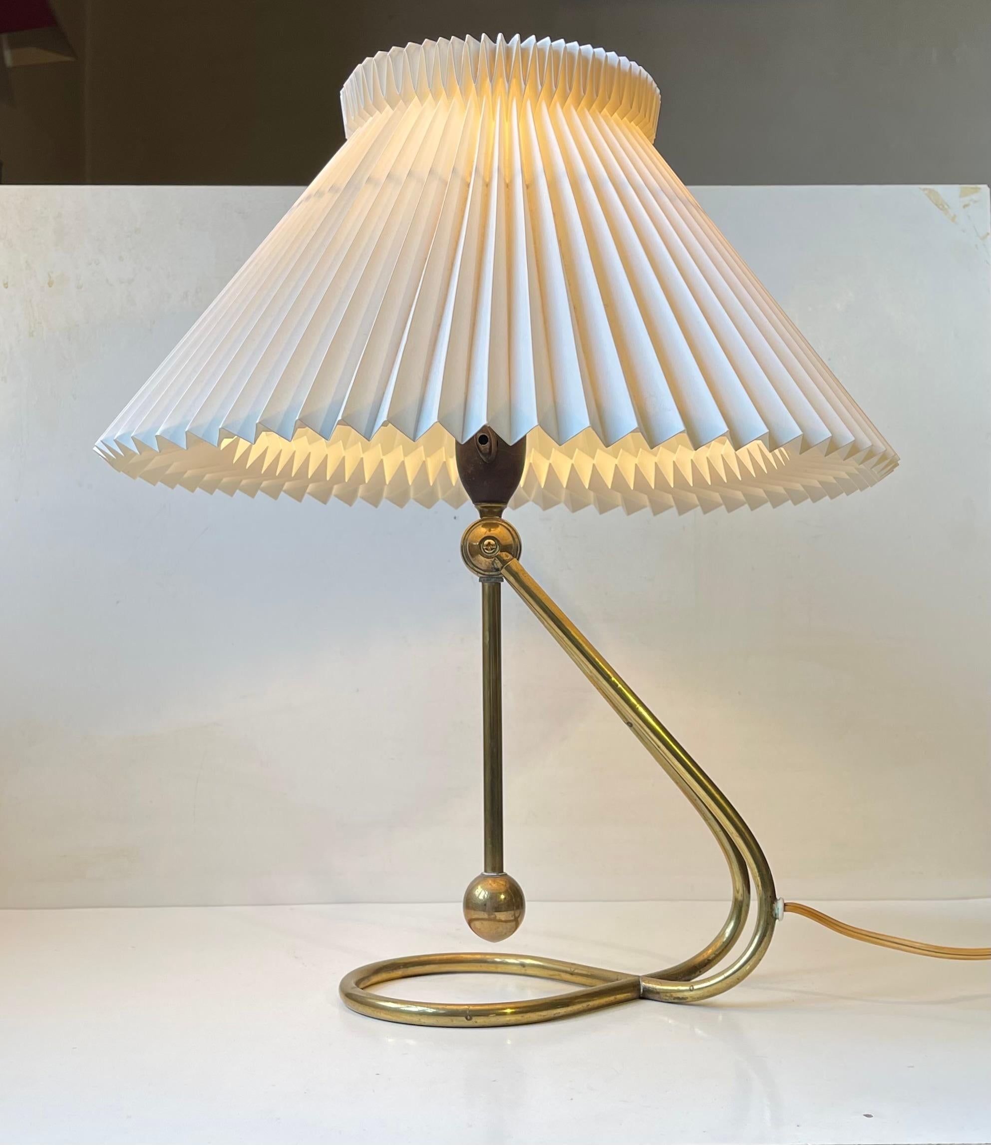Exceptionally rare table or wall lamp with an adjustable base in solid tubular brass featuring its original bakelite socket and the characteristic fluted white Le Klint shade. This example dates from the 1950s and it has an updated/more recent