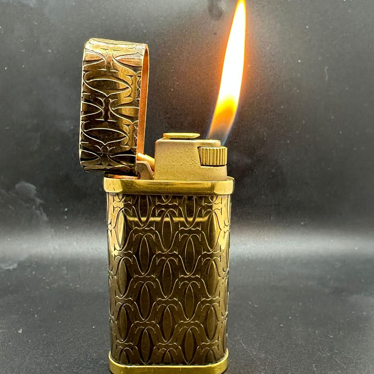 Le must de Cartier logo gold lighter 
Cartier Lighter Gold plated  18k Gold  
Comes with original Cartier case
In mint exterior and working condition  
Circa 2000 In great condition  
The lighter ignites, sparks and flames