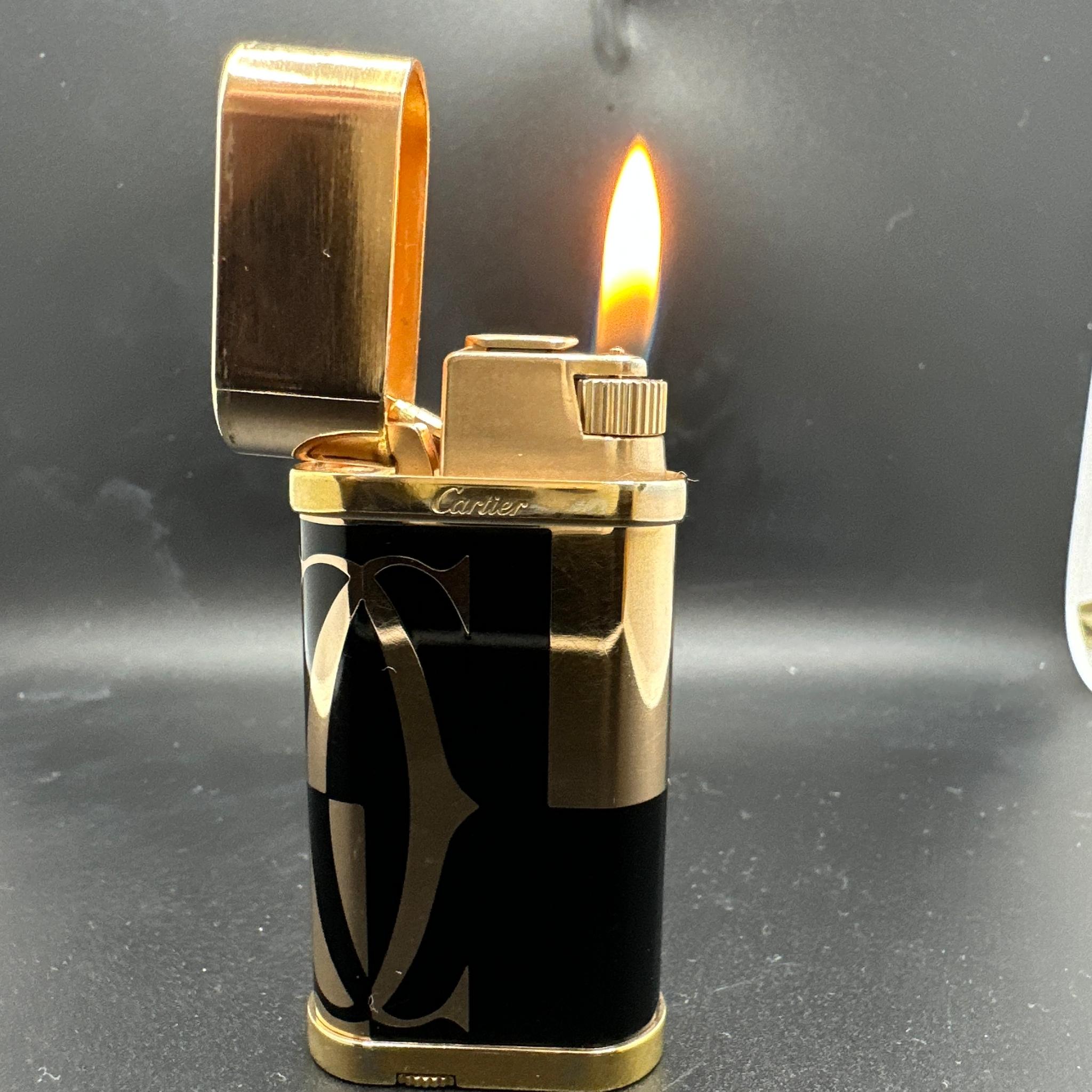 Cartier Oval lighter with logotype decor - Yellow Gold plated and Black Lacquer.
This is an out of stock yellow gold and black Cartier.
One owner, rare lighter, in great working condition. 
Beautiful.
Come with the original Cartier box and papers.