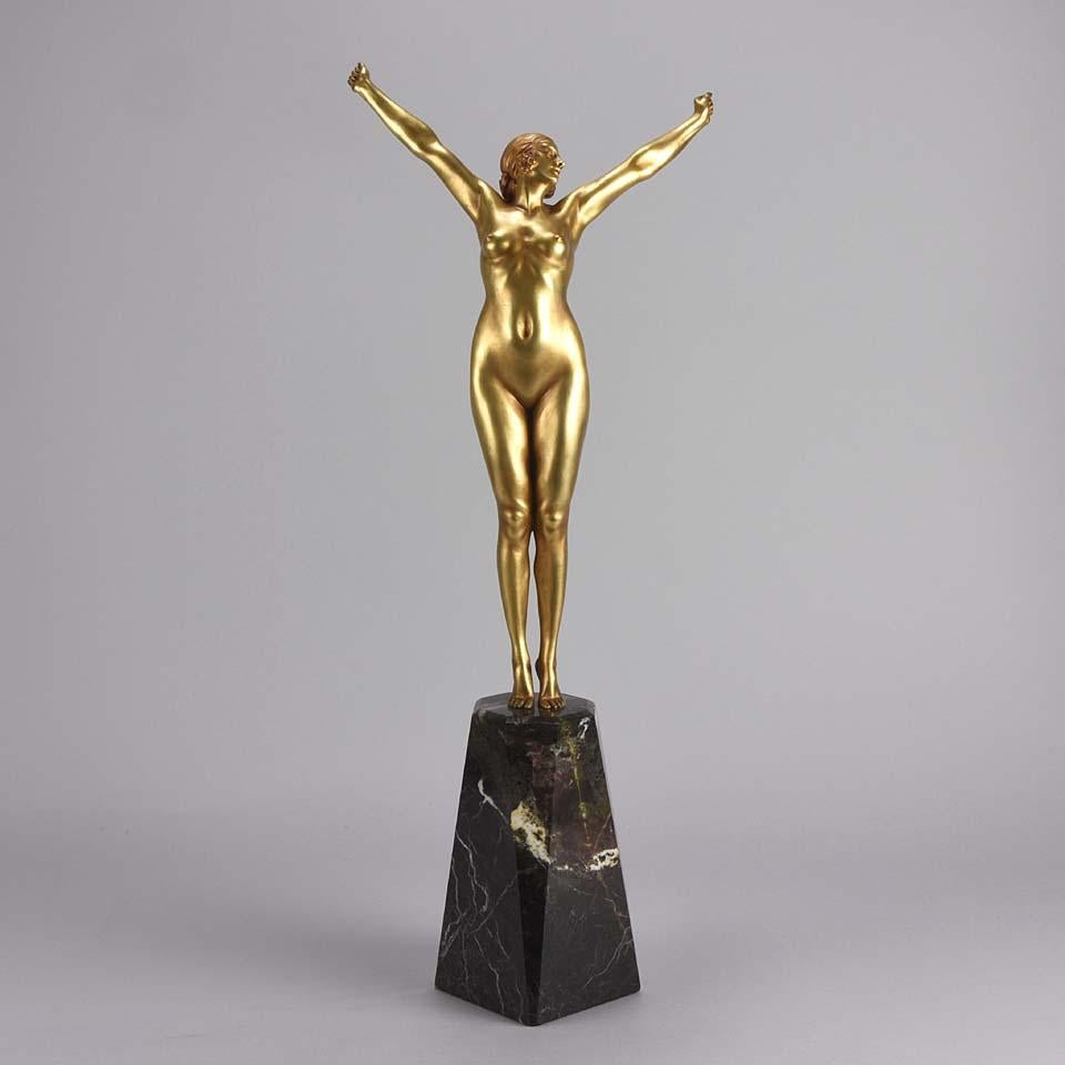 An exquisite and very rare Art Deco bronze figure from this famous artist's oeuvre. The bronze figurine modelled as an elegant young beauty, naked as she stretches in the early morning. The surface of the bronze has a wonderful gilt heightened